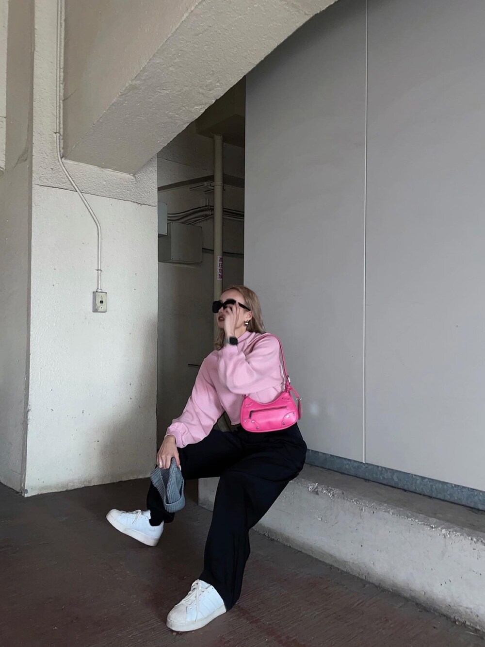 ピンク系のスウェット、ブラック系のその他パンツを着用したレディースの冬コーディネートの3枚目の写真