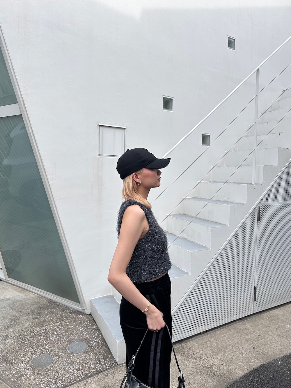 グレー系のタンクトップ、ブラック系のその他パンツ、ブラック系のハンドバッグを着用したレディースの夏コーディネートの4枚目の写真