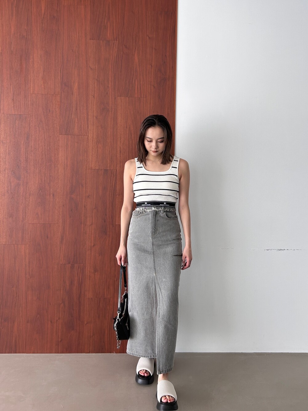 その他のタンクトップ、グレー系のデニムスカート、ホワイト系のサンダルを着用したレディースの春コーディネートの3枚目の写真