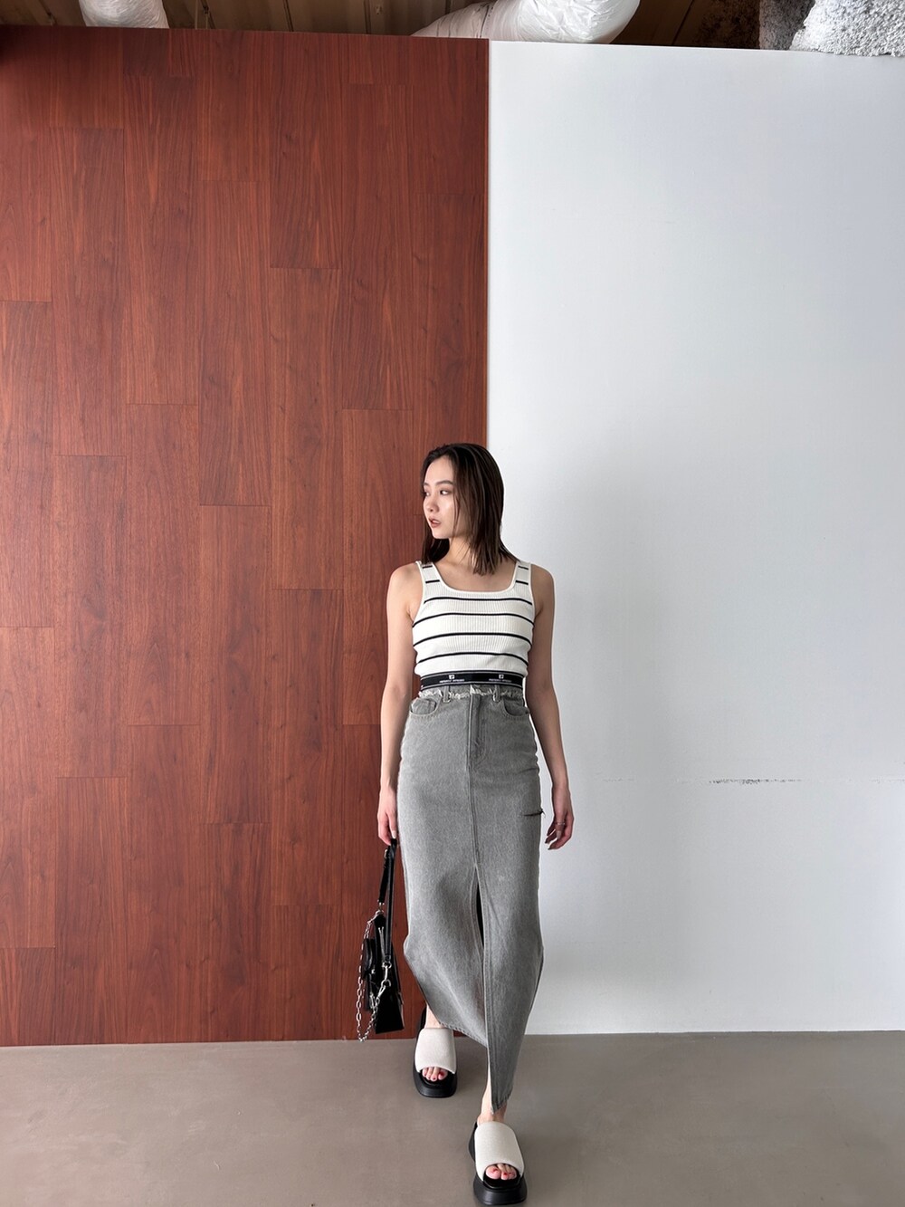 その他のタンクトップ、グレー系のデニムスカート、ホワイト系のサンダルを着用したレディースの春コーディネートの2枚目の写真