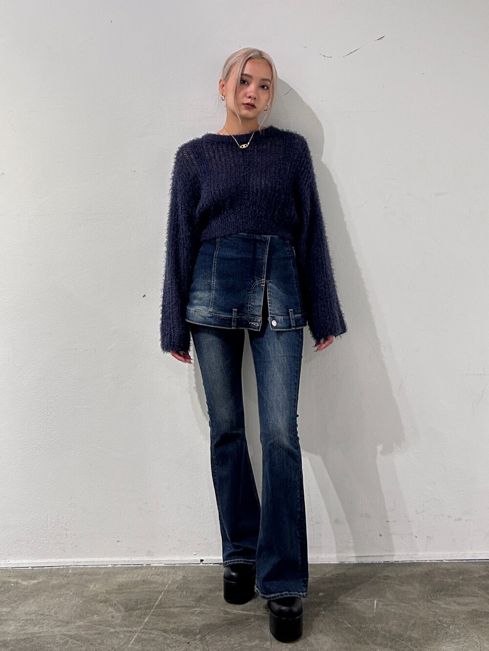ブルー系のニット/セーター、ブルー系のデニムパンツ、ブラック系のブーツを着用したレディースの秋コーディネートの3枚目の写真