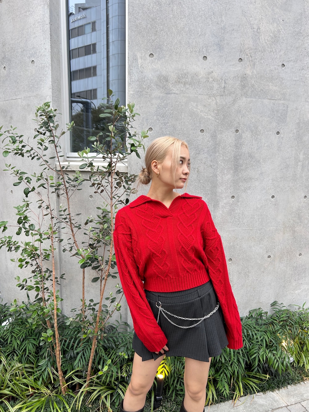レッド系のニット/セーター、ブラック系のブーツを着用したレディースの秋コーディネートの5枚目の写真