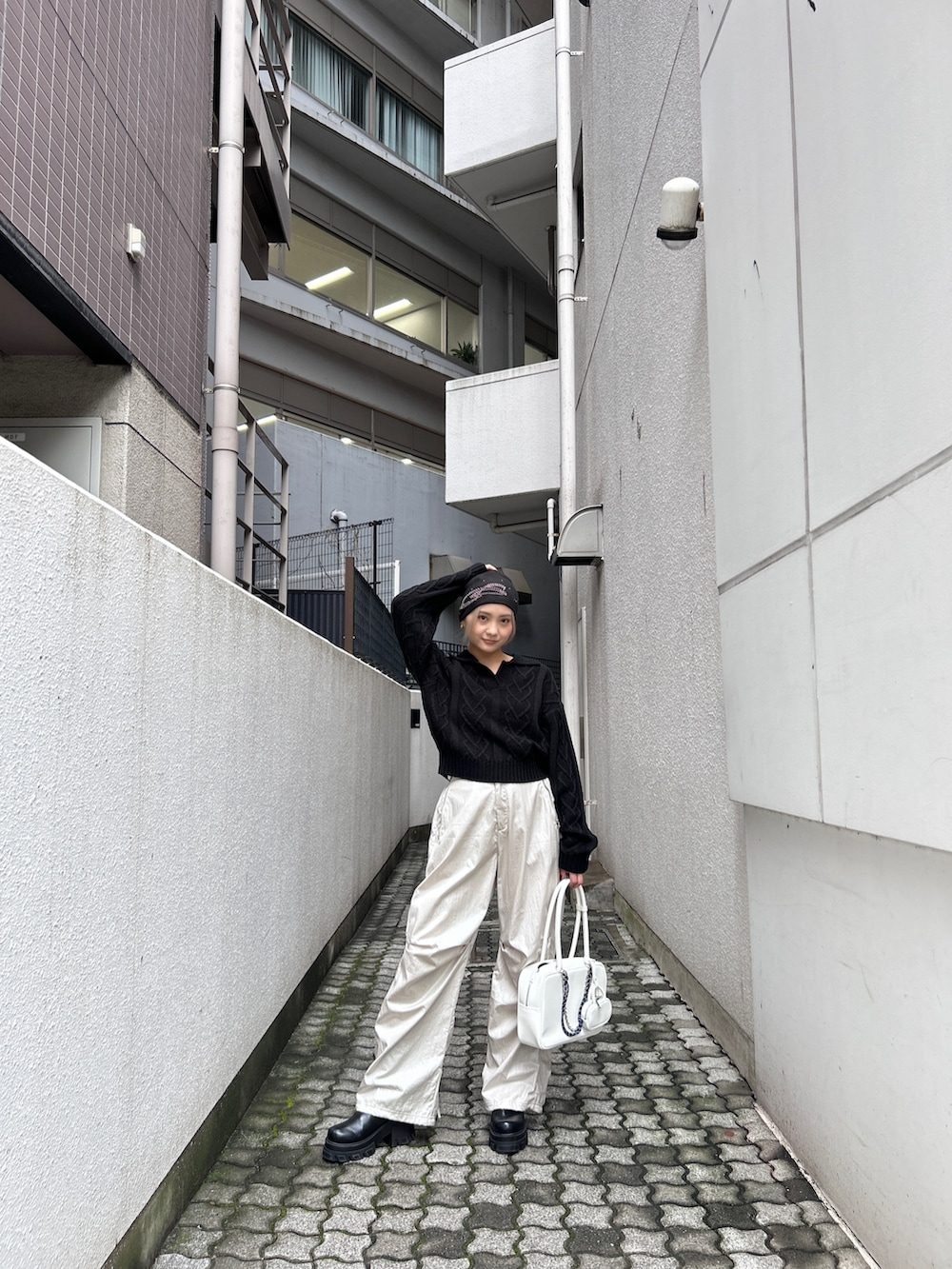 レッド系のニット/セーター、ホワイト系のその他パンツ、ブラック系のブーツを着用したレディースの秋コーディネートの3枚目の写真