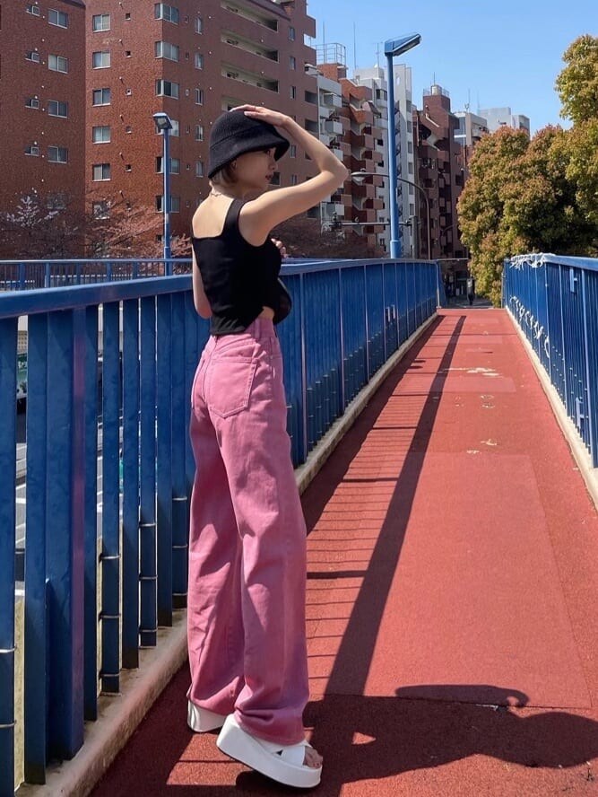 ピンク系のデニムパンツ、ブラック系のタンクトップを着用したレディースの夏コーディネートの4枚目の写真