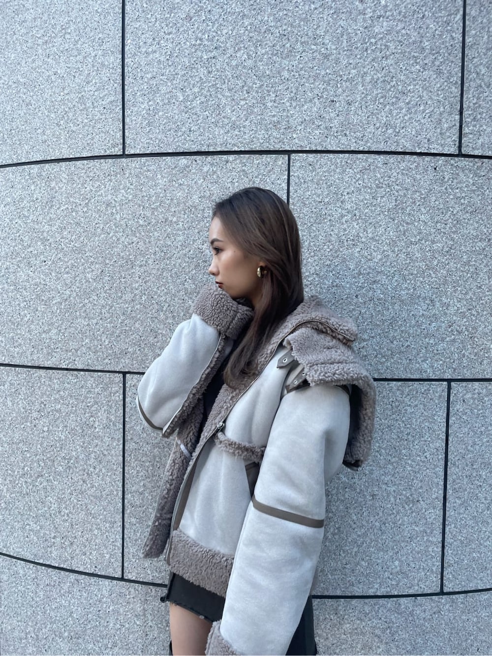 グレー系のムートンコートを着用したレディースの冬コーディネートの3枚目の写真