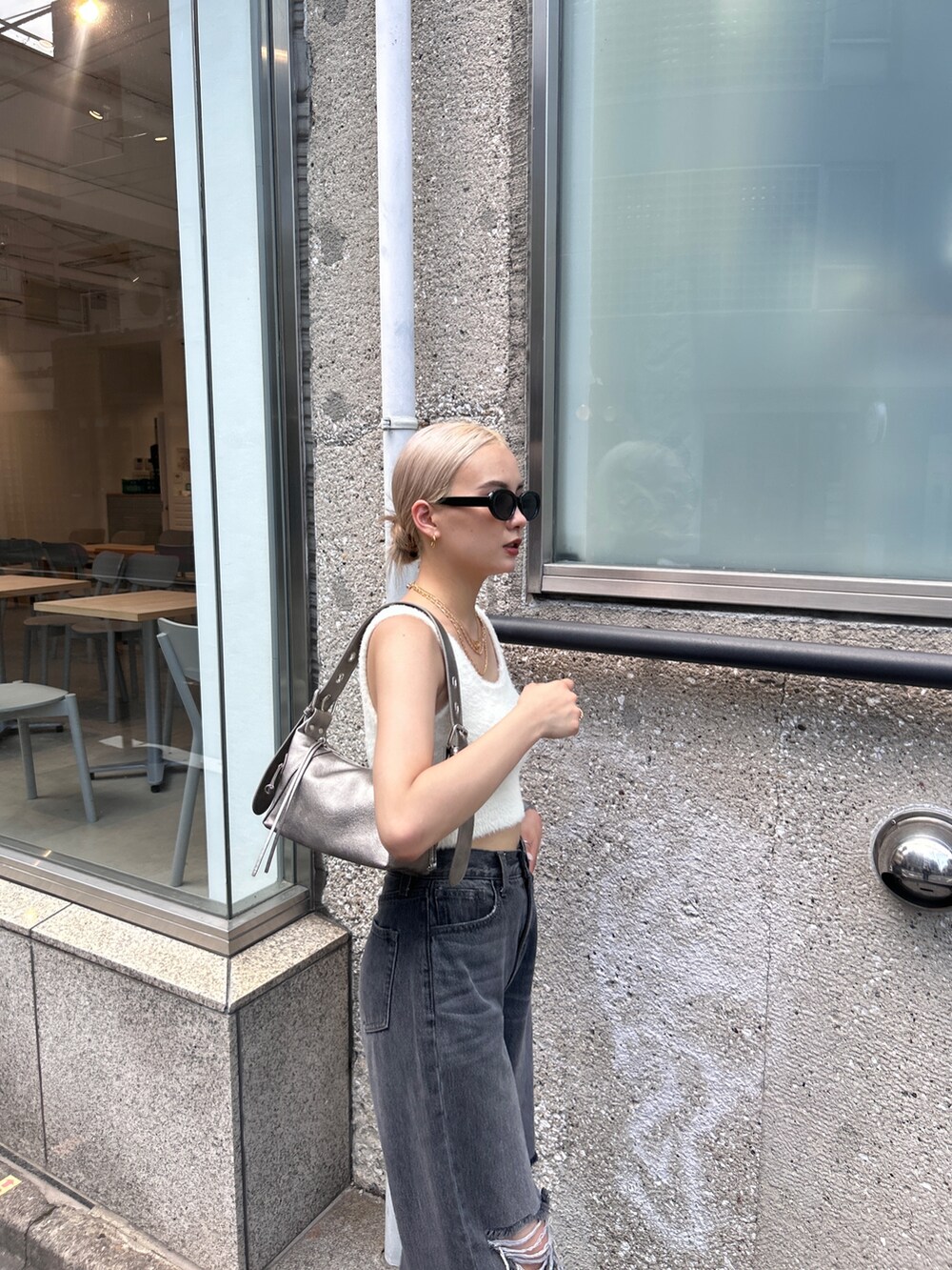 ホワイト系のニット/セーター、グレー系のデニムパンツ、シルバー系のハンドバッグを着用したレディースの夏コーディネートの6枚目の写真