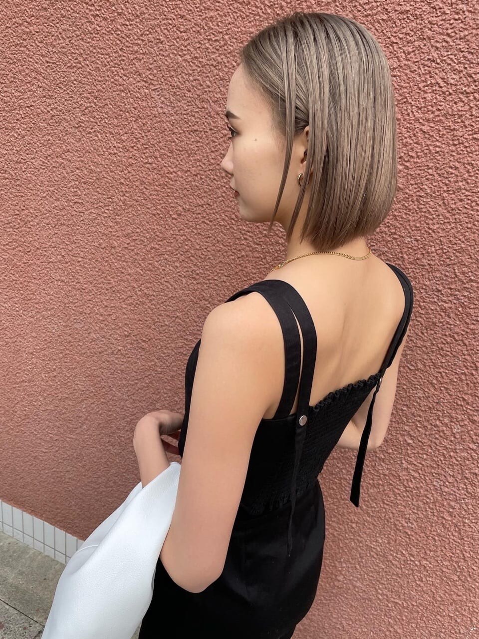 ブラック系のスカート、ブラック系のタンクトップを着用したレディースの春コーディネートの2枚目の写真