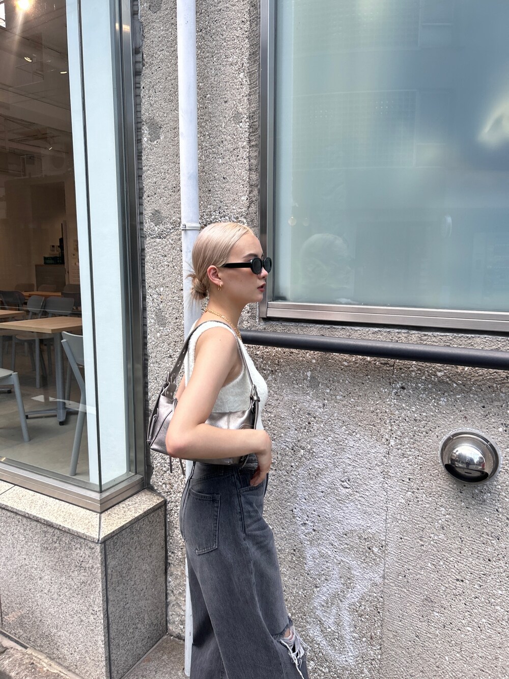 ホワイト系のニット/セーター、グレー系のデニムパンツ、シルバー系のハンドバッグを着用したレディースの夏コーディネートの5枚目の写真