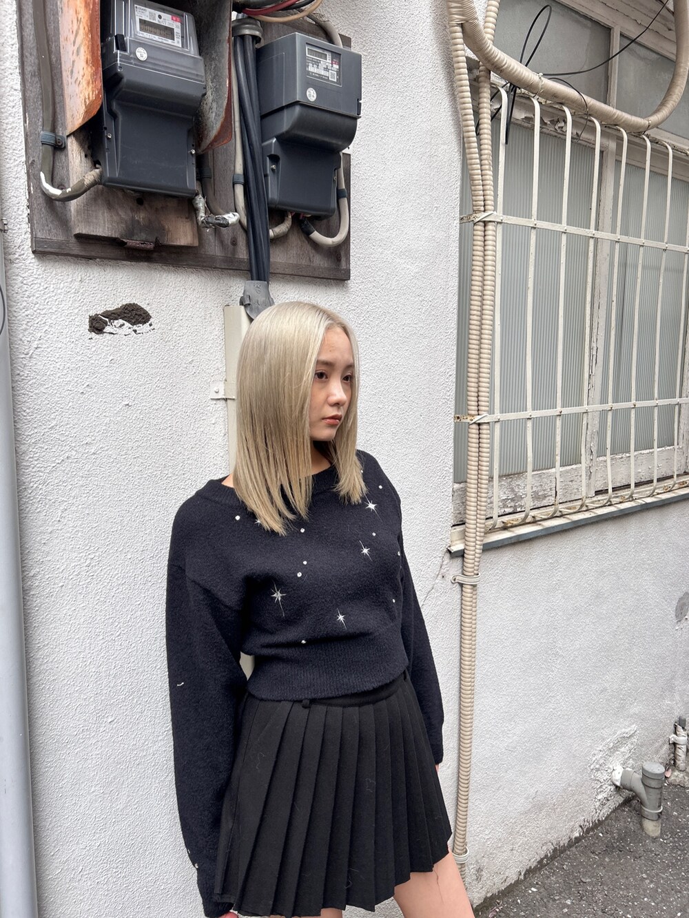 ブラック系のニット/セーター、ブラック系のスカート、その他のブーツを着用したレディースの冬コーディネートの5枚目の写真