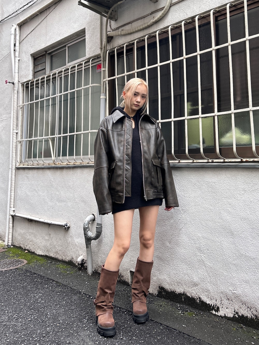 ブラック系のブルゾン、ブラウン系のブーツ、ブラック系のニット/セーターを着用したレディースの秋コーディネートの3枚目の写真