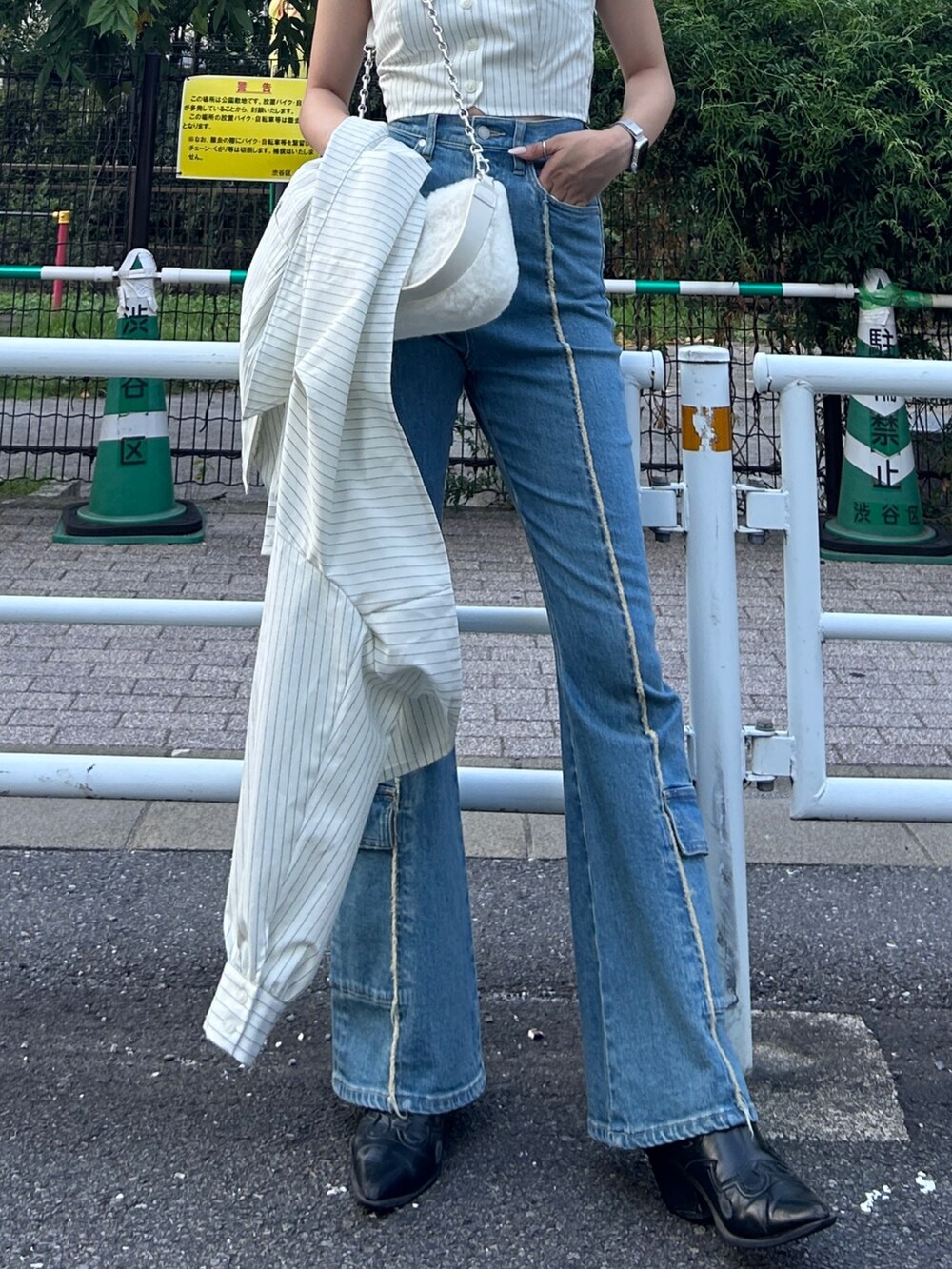 ブルー系のデニムパンツ、ホワイト系のハンドバッグを着用したレディースの秋コーディネートの2枚目の写真