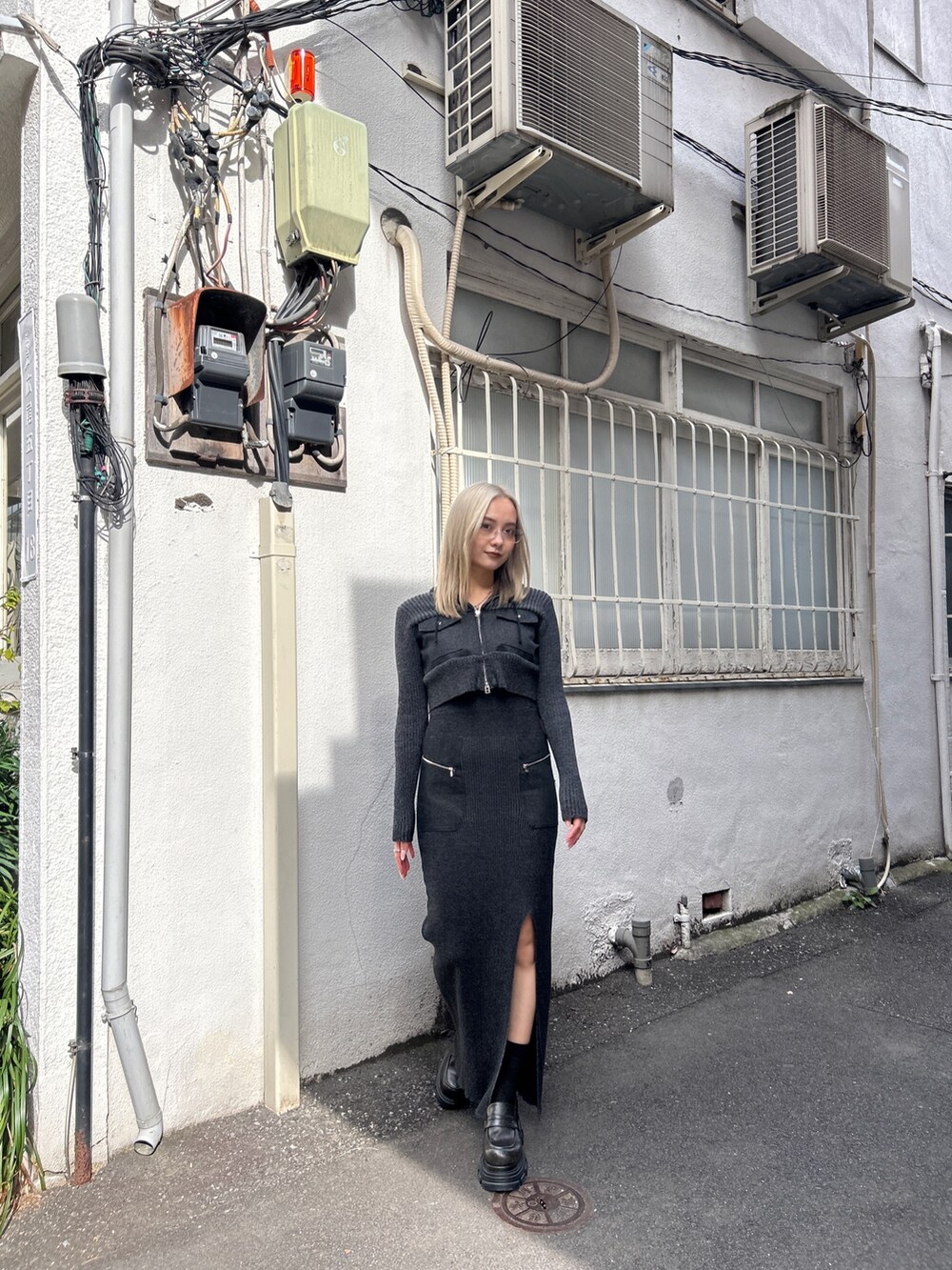 ブラック系のニット/セーター、ブラック系のスカート、ブラック系のブーツを着用したレディースの冬コーディネートの2枚目の写真