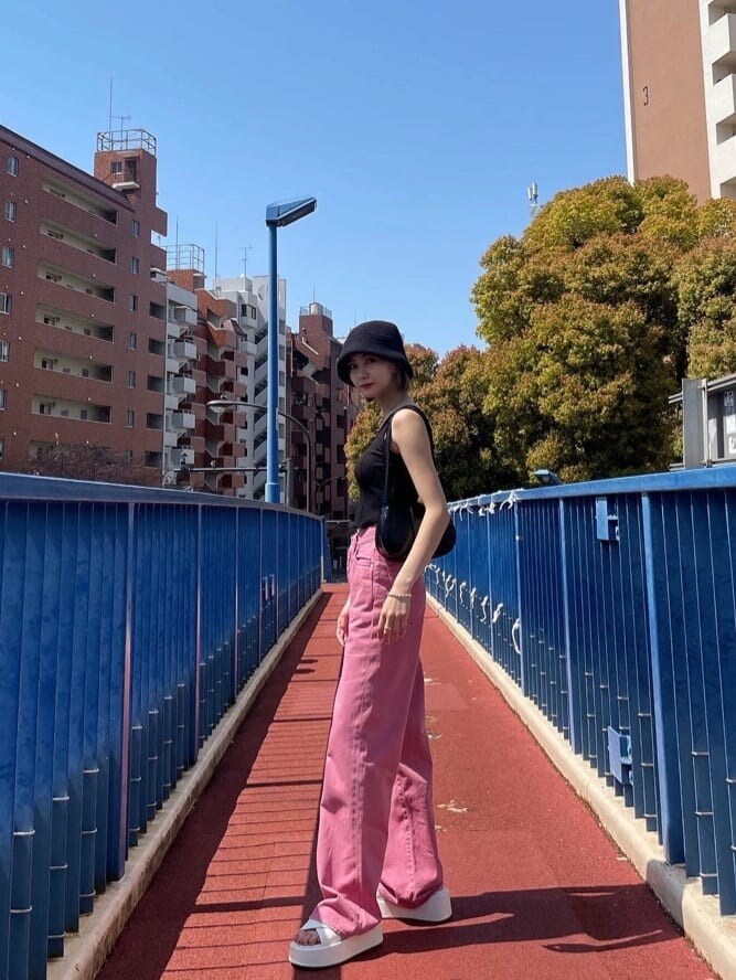 ピンク系のデニムパンツ、ブラック系のタンクトップを着用したレディースの夏コーディネートの3枚目の写真