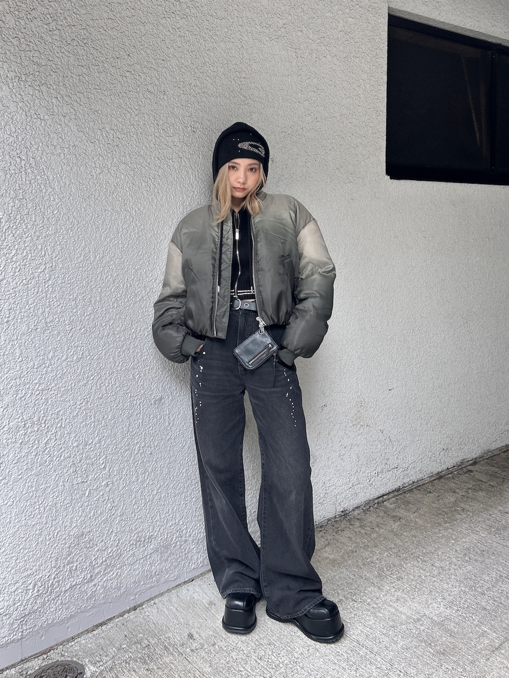 グレー系のブルゾン、ブラック系のデニムパンツ、ブラック系のローファーを着用したレディースの秋コーディネートの3枚目の写真