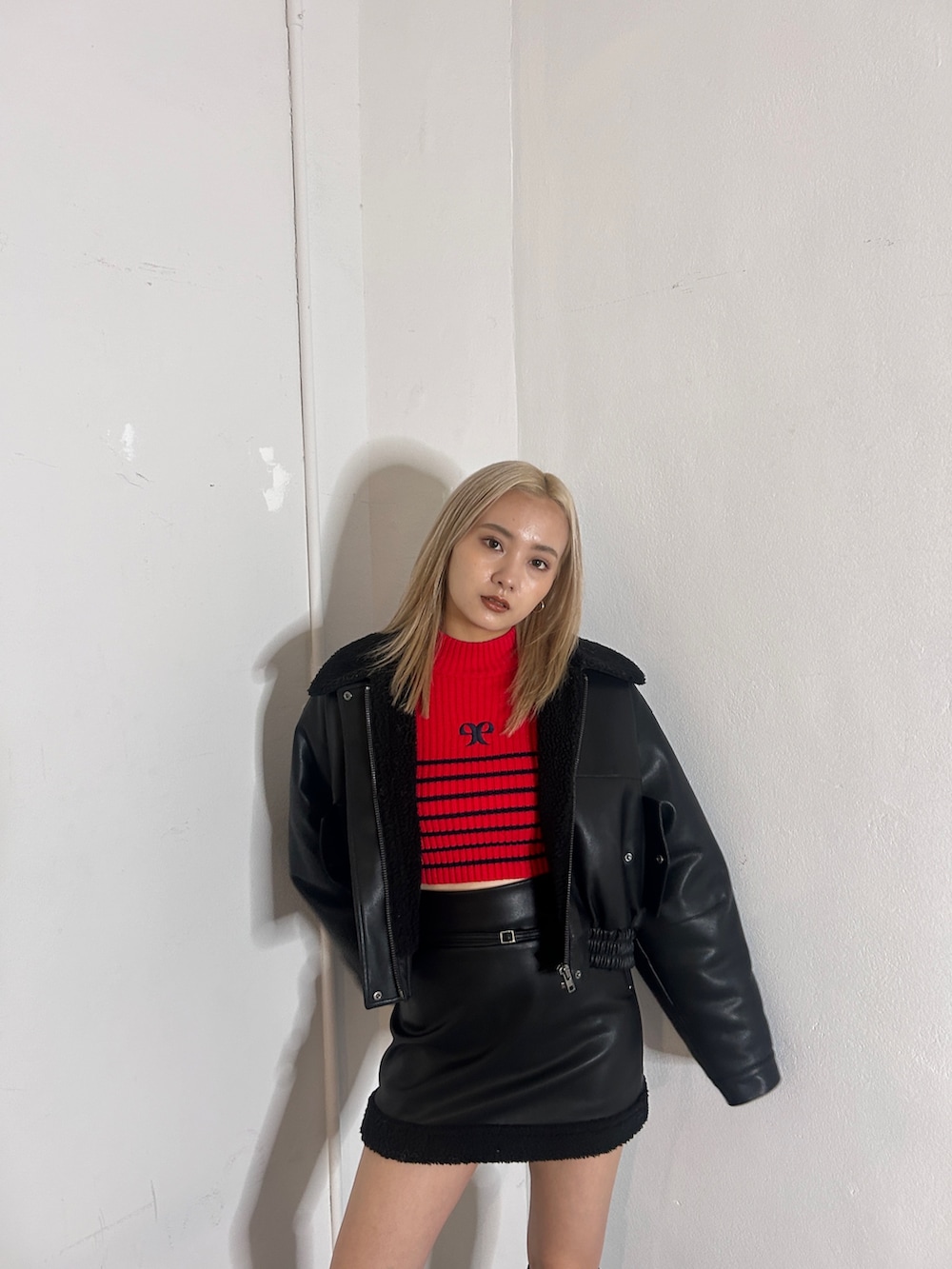 グレー系のブルゾン、ブラック系のスカート、ブラック系のブーツを着用したレディースの秋コーディネートの2枚目の写真