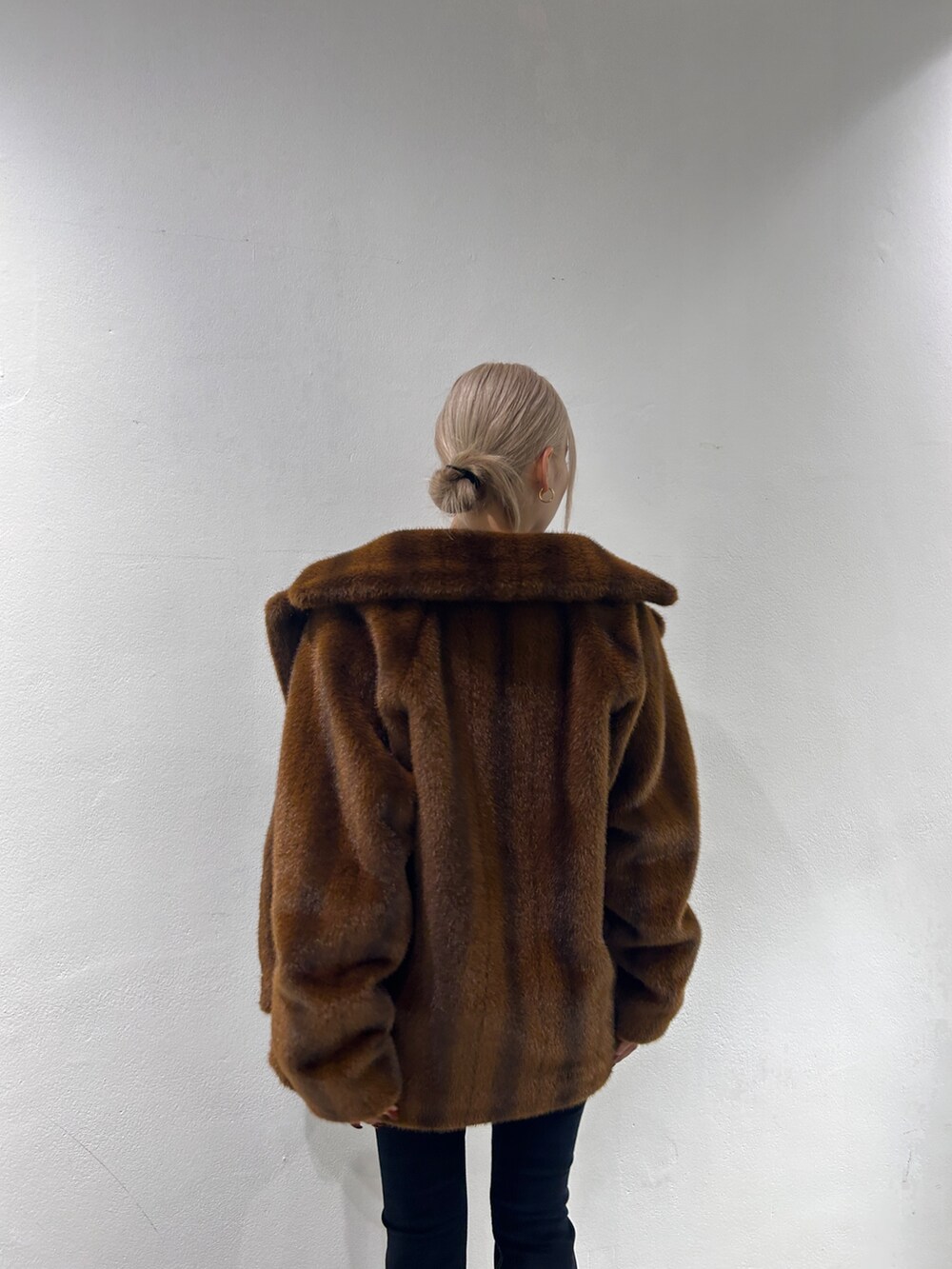 ブラウン系のその他アウター、ブラック系のデニムパンツ、ブラック系のブーツを着用したレディースの秋コーディネートの4枚目の写真