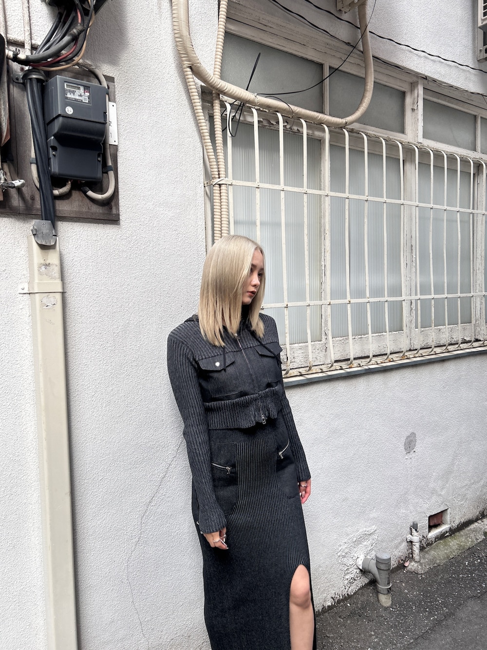 ブラック系のニット/セーター、ブラック系のスカート、ブラック系のブーツを着用したレディースの冬コーディネートの7枚目の写真