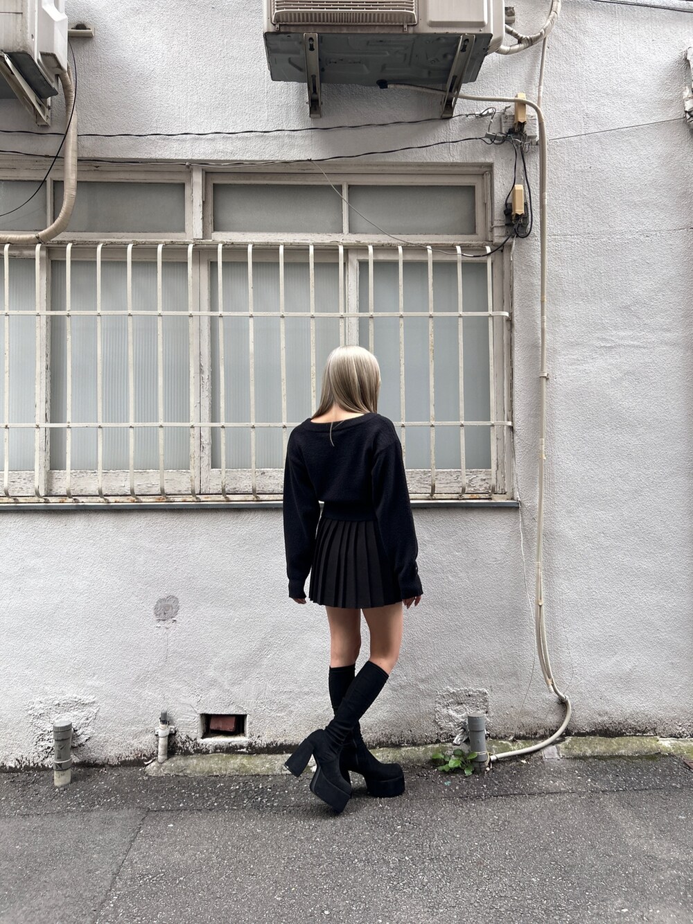 ブラック系のニット/セーター、ブラック系のスカート、その他のブーツを着用したレディースの冬コーディネートの4枚目の写真