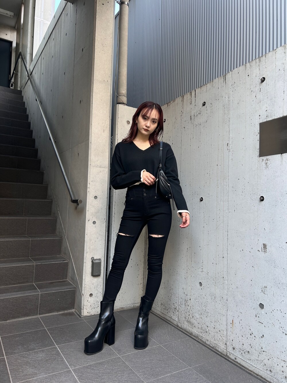 ブラック系のデニムパンツ、ブラック系のブーツ、ブラック系のニット/セーターを着用したレディースの冬コーディネートの2枚目の写真
