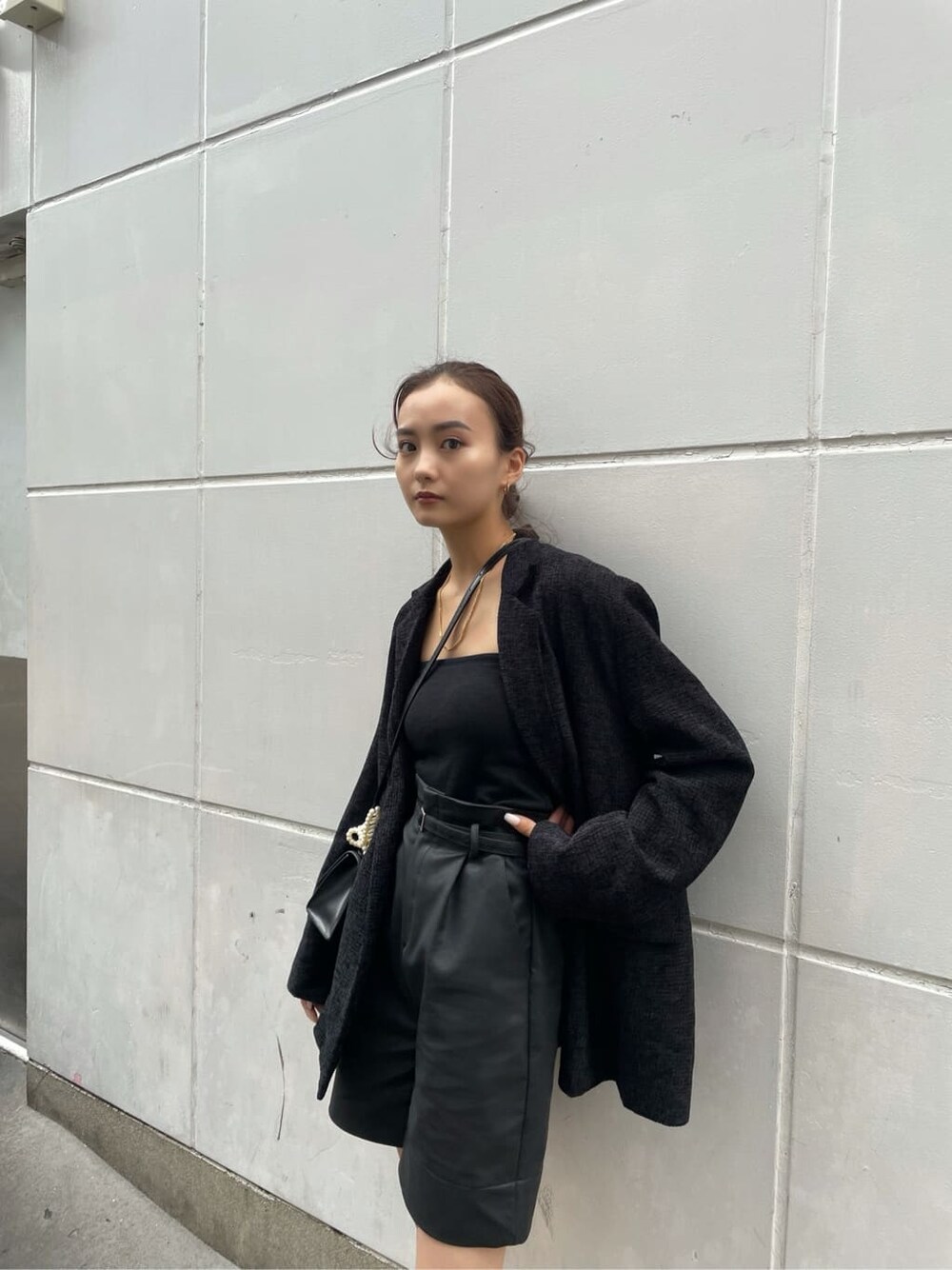 ブラック系のキャミソール、ブラック系のテーラードジャケット、ブラック系のその他パンツを着用したレディースの秋コーディネートの2枚目の写真