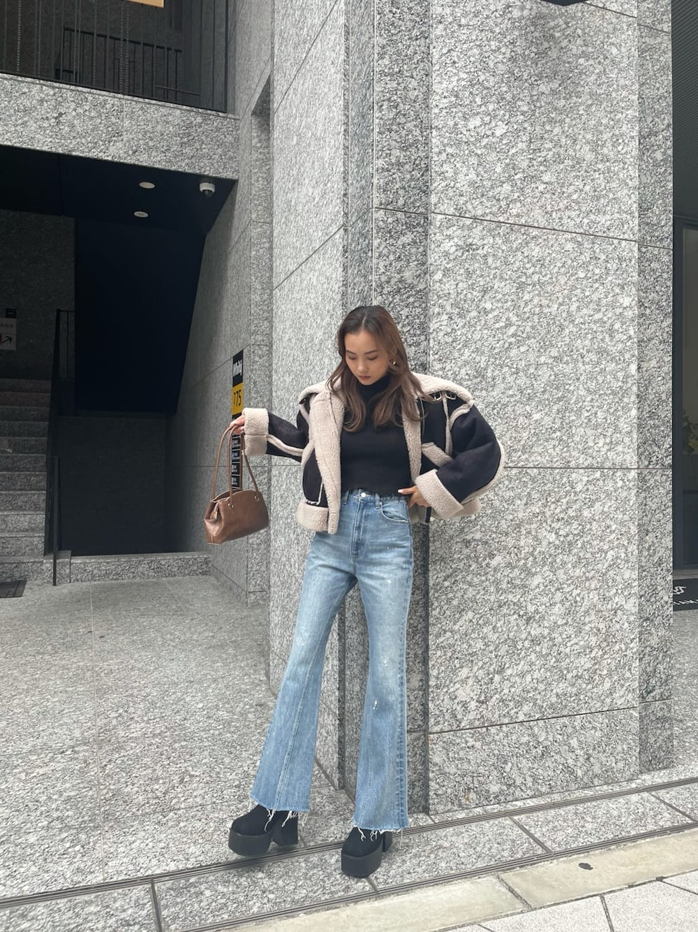 その他のムートンコート、ブルー系のデニムパンツを着用したレディースの秋コーディネートの2枚目の写真