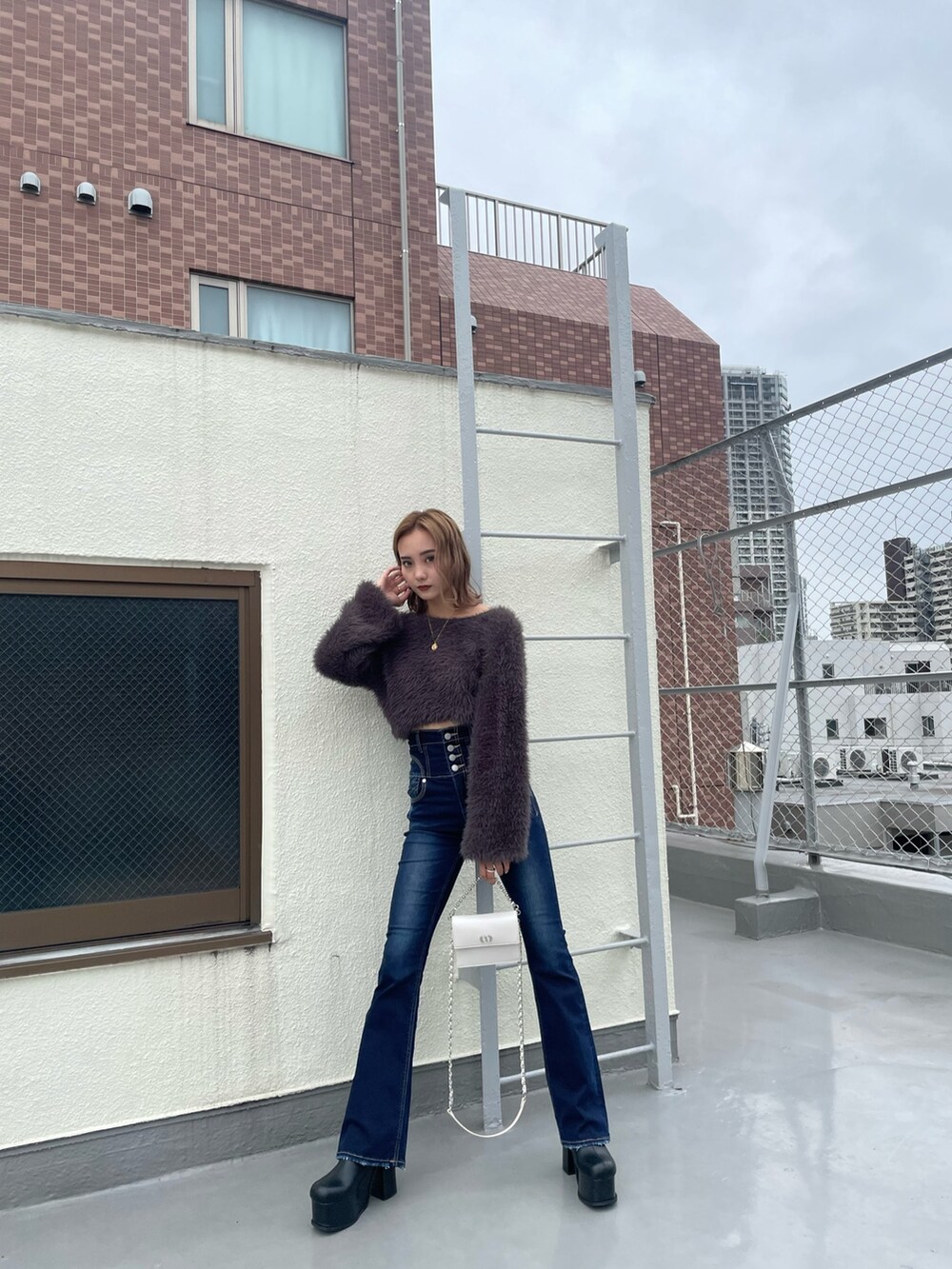 グレー系のニット/セーター、ブルー系のデニムパンツを着用したレディースの冬コーディネートの5枚目の写真