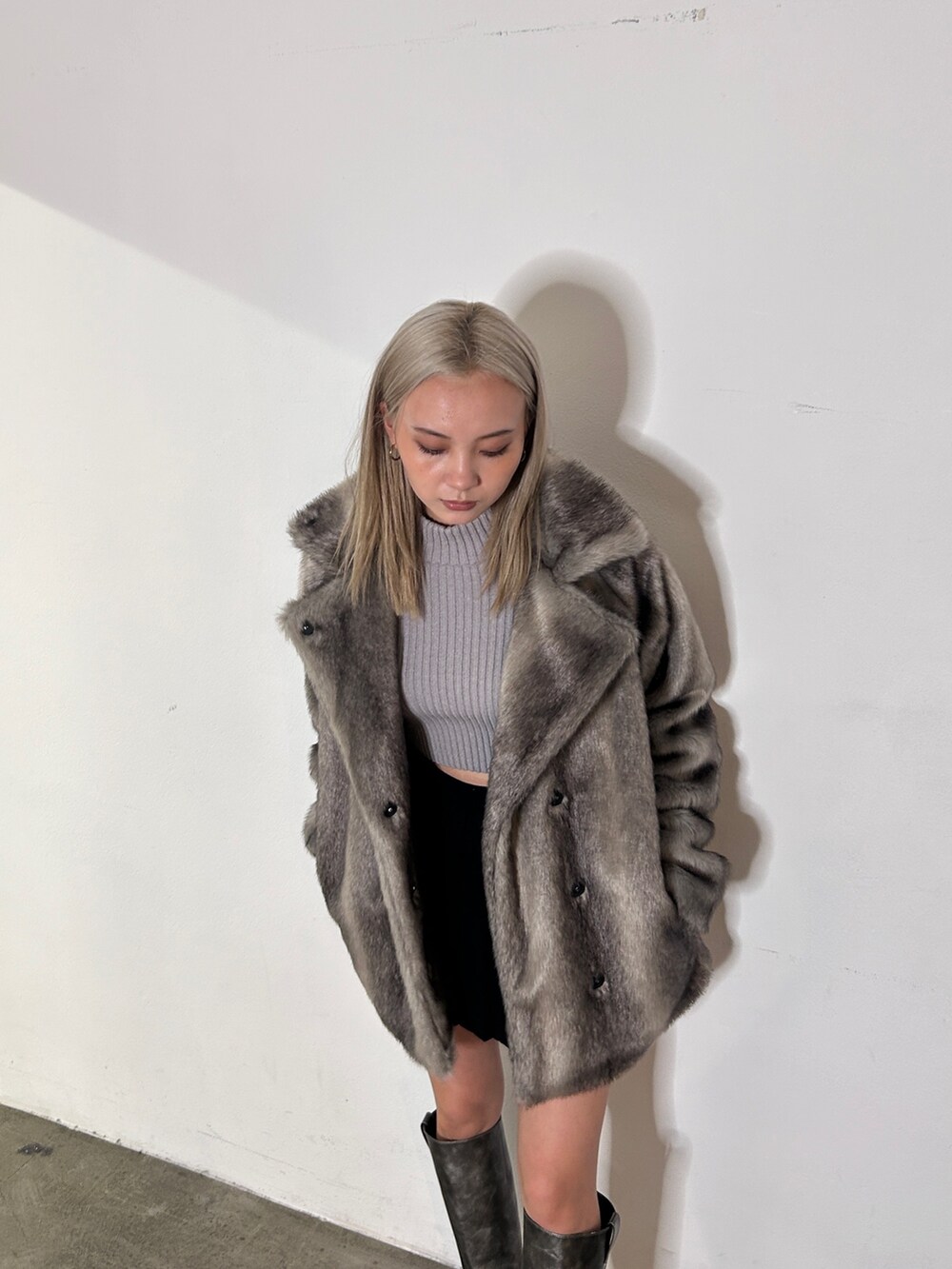 グレー系のその他アウター、グレー系のニット/セーター、シルバー系のブーツを着用したレディースの冬コーディネートの3枚目の写真