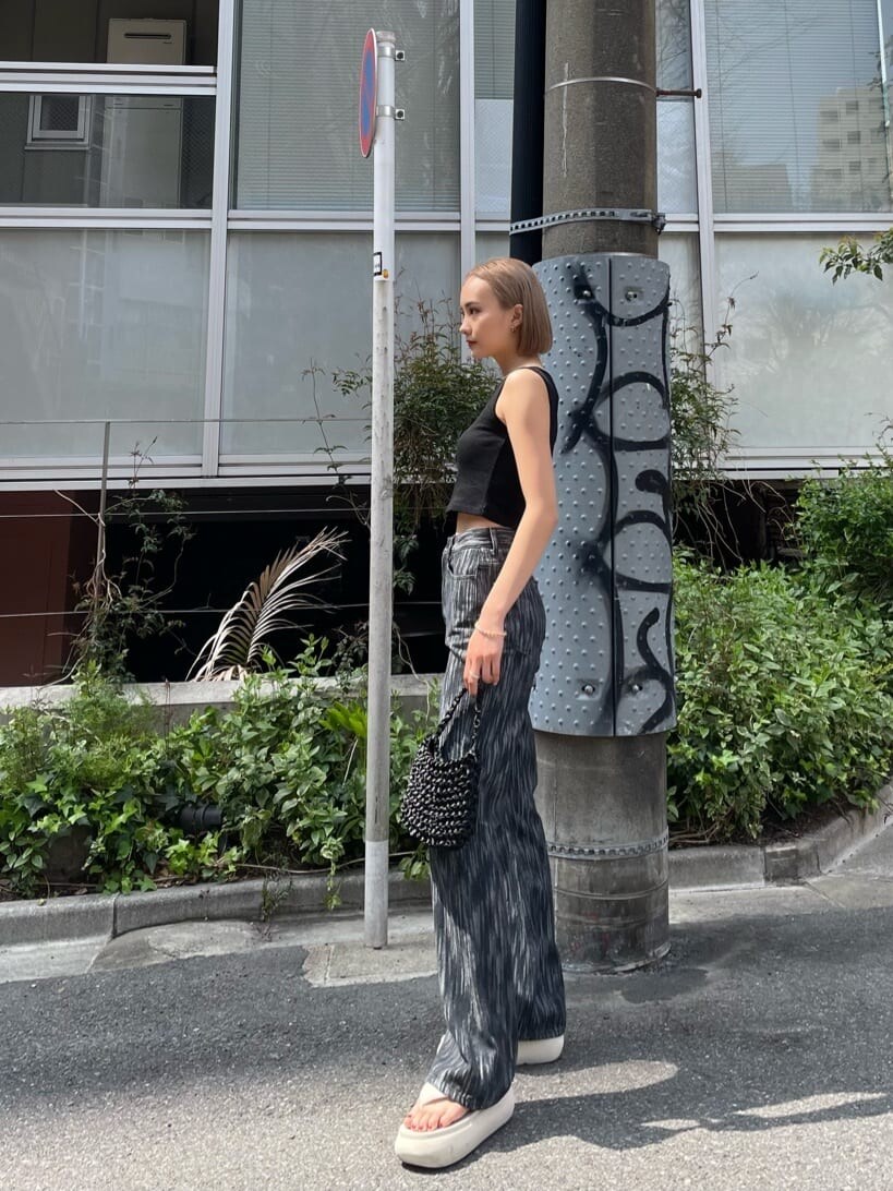 ブラック系のデニムパンツを着用したレディースの春コーディネートの2枚目の写真