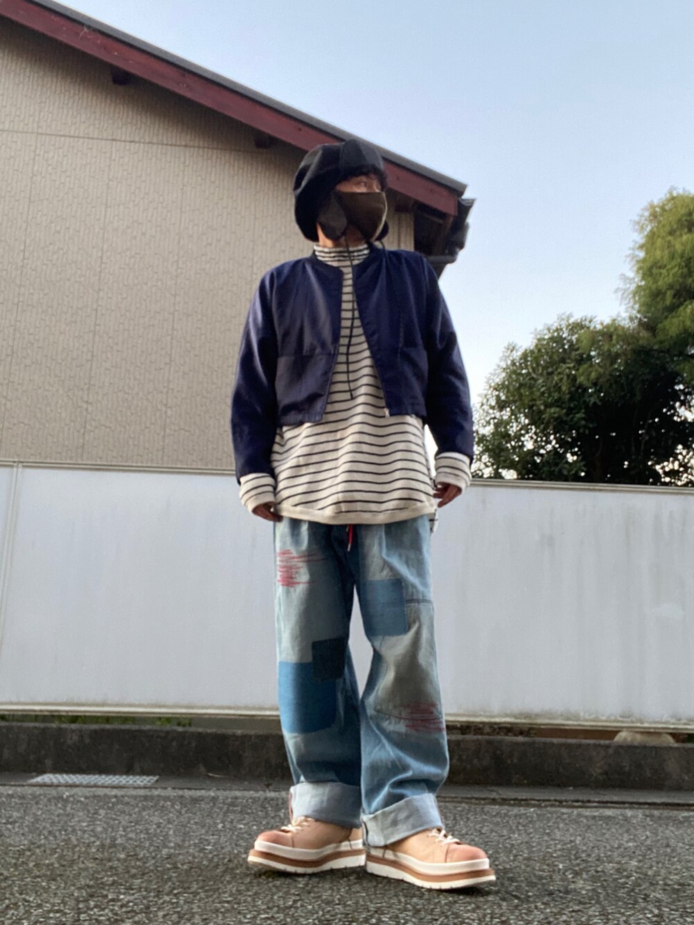 ブルー系のデニムパンツ、ホワイト系のニット/セーター、ブルー系のナイロンジャケットを着用したメンズの秋コーディネートの2枚目の写真