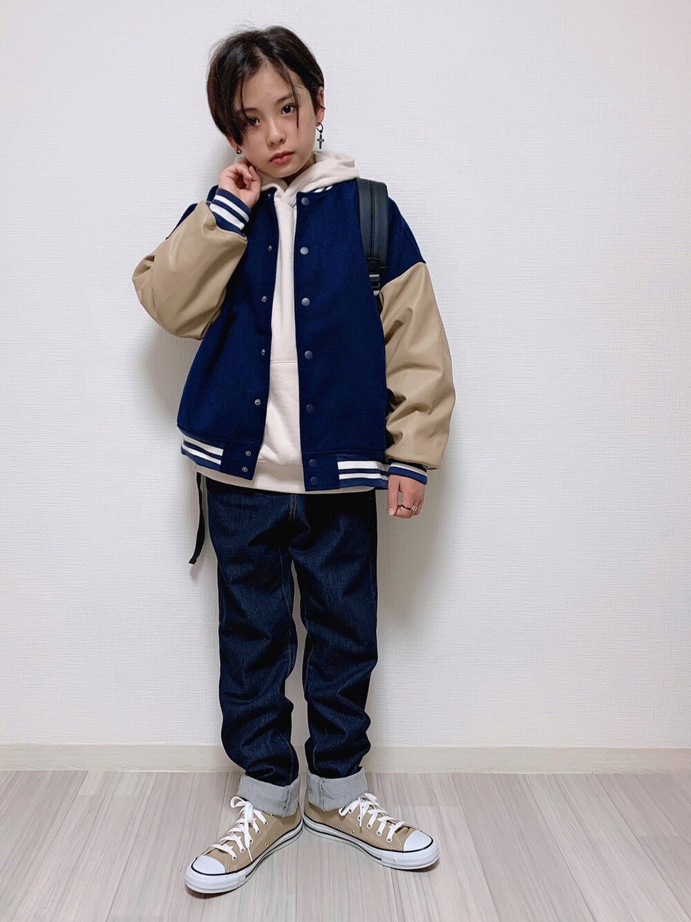 ブルー系のスタジャン、ベージュ系のパーカー、ブルー系のデニムパンツを着用したキッズの冬コーディネートの3枚目の写真