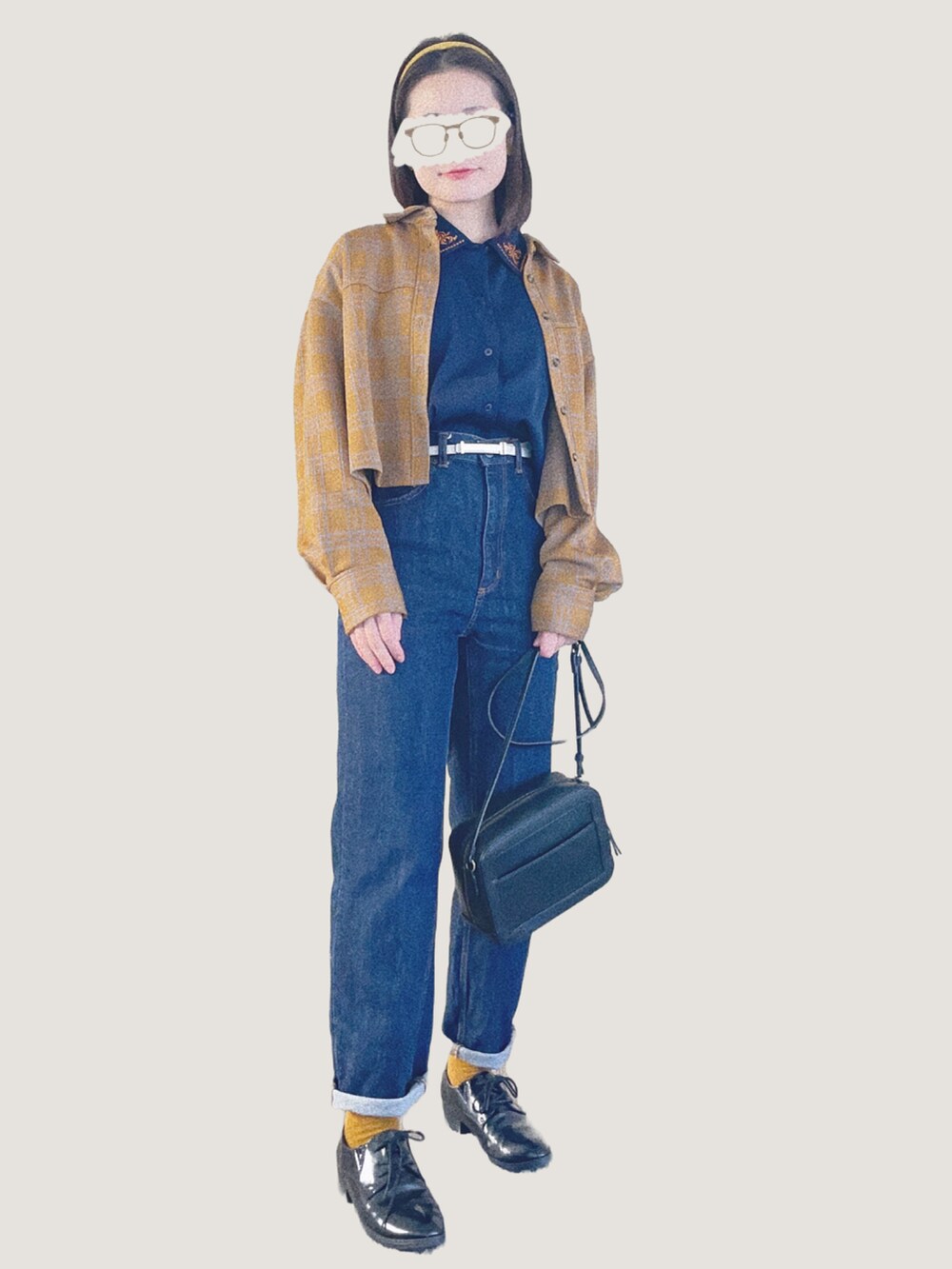 ブルー系のデニムパンツ、ブラック系のショルダーバッグ、ブラック系のドレスシューズを着用したレディースの冬コーディネートの2枚目の写真