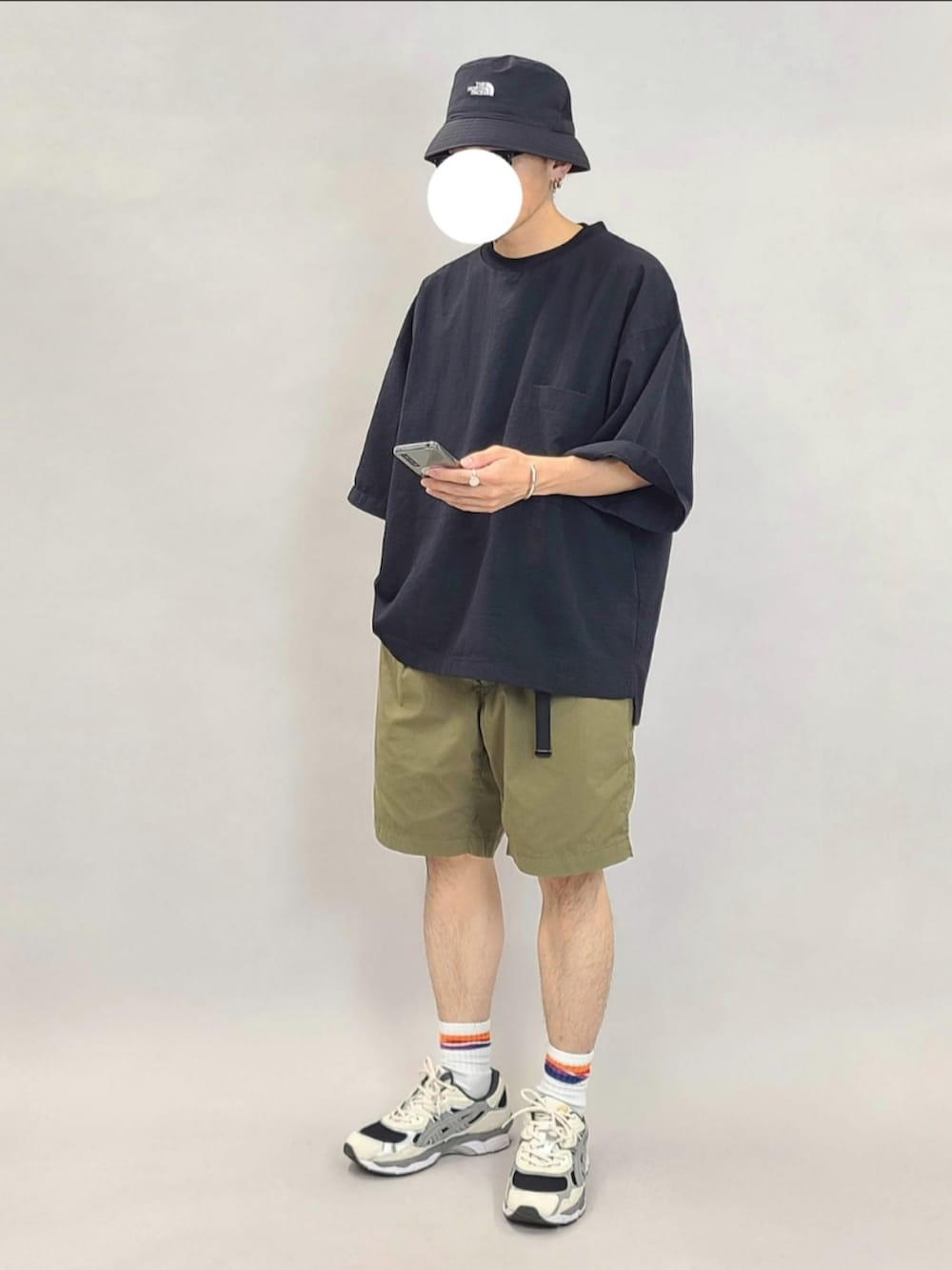 グリーン系のパンツ、ホワイト系のスニーカーを着用したメンズの秋コーディネートの2枚目の写真