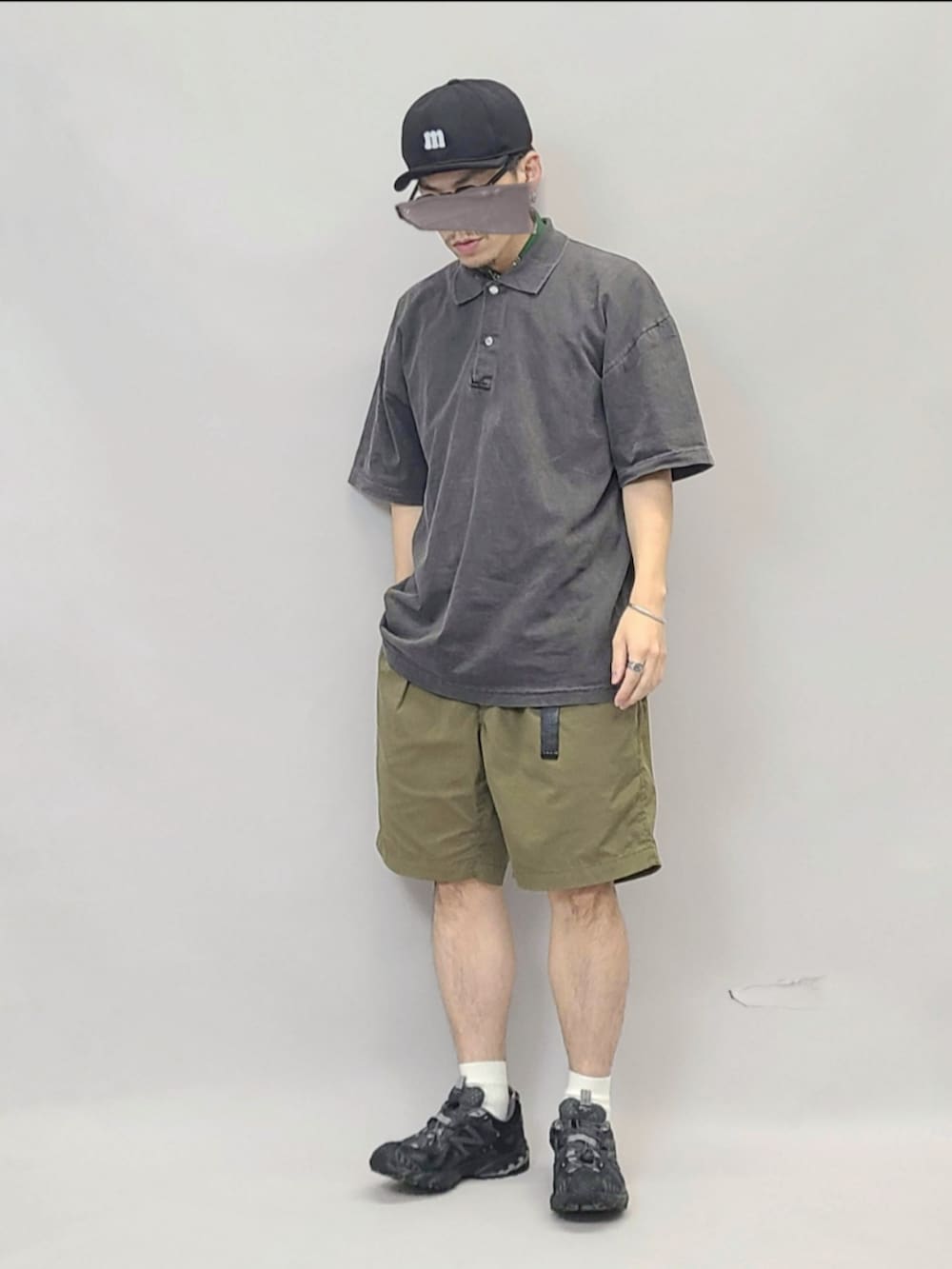 ブラック系のスニーカー、ブラック系のポロシャツ、ブラック系のキャップを着用したメンズの秋コーディネートの3枚目の写真