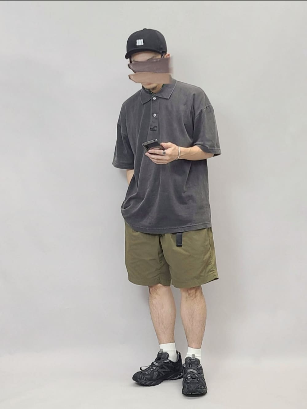 ブラック系のスニーカー、ブラック系のポロシャツ、ブラック系のキャップを着用したメンズの秋コーディネートの2枚目の写真