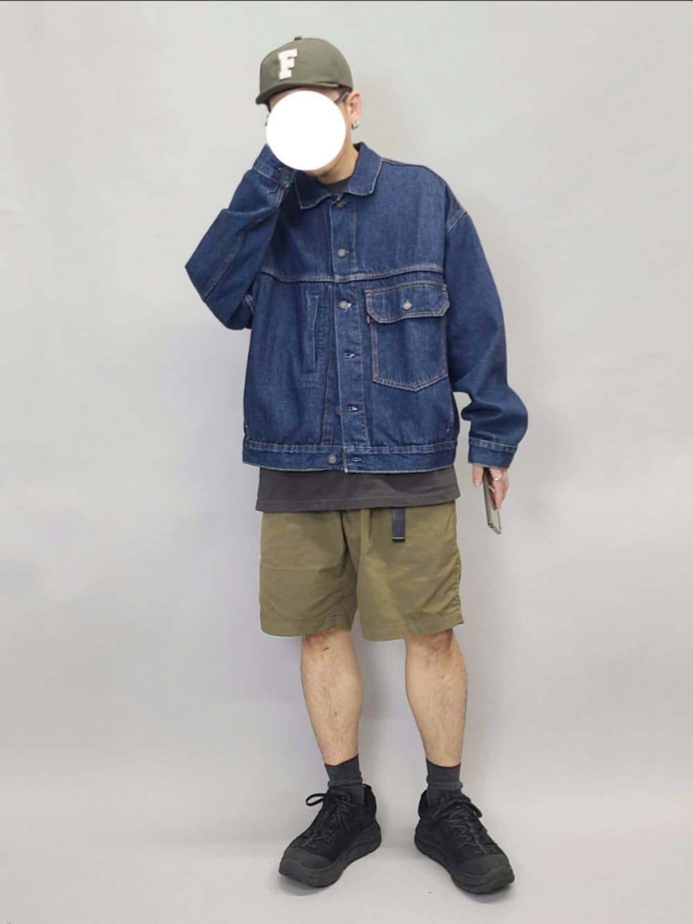 ブルー系のデニムジャケット、ブラック系のTシャツ/カットソー、ブラック系のスニーカーを着用したメンズの秋コーディネートの4枚目の写真