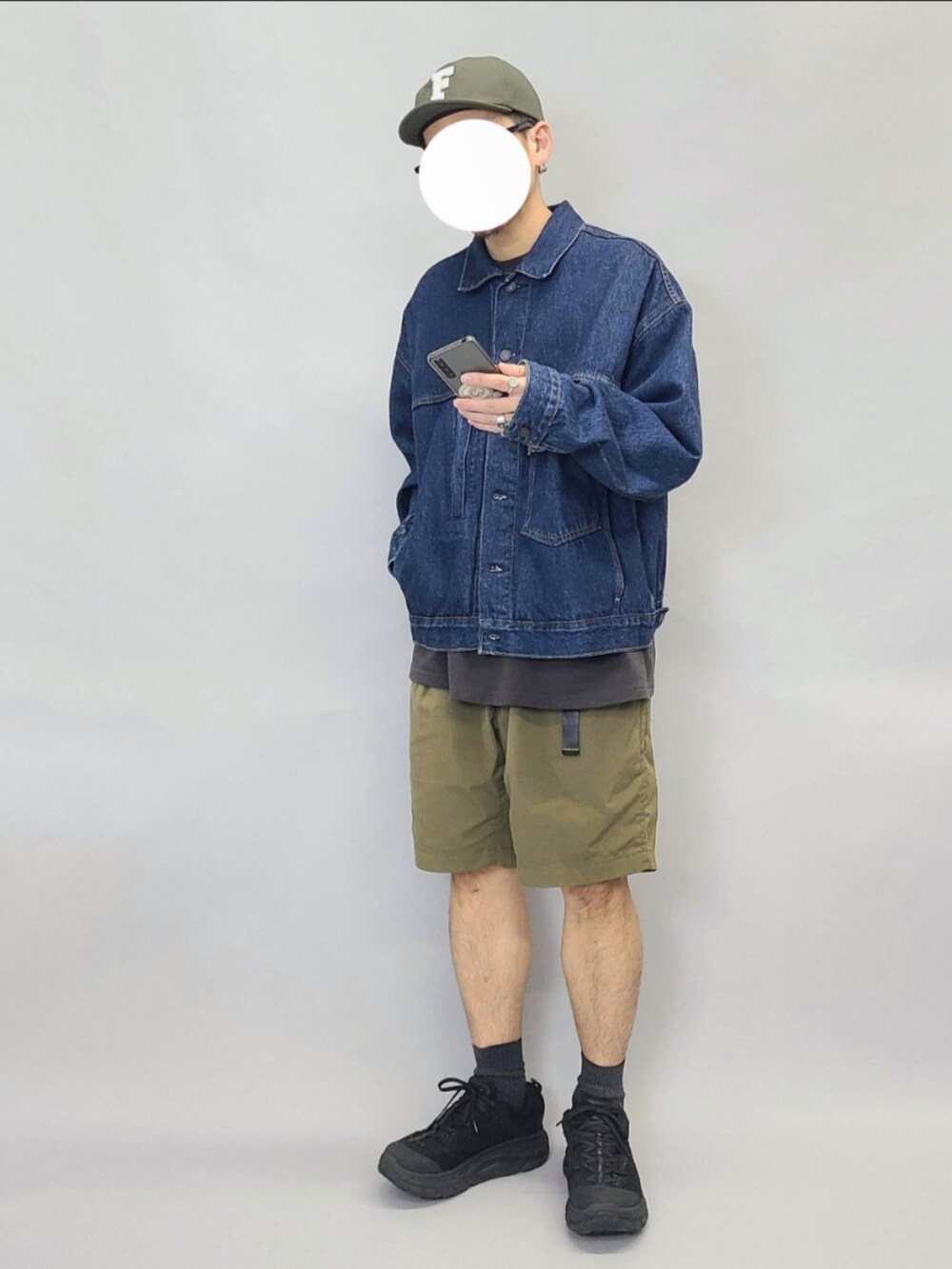 ブルー系のデニムジャケット、ブラック系のTシャツ/カットソー、ブラック系のスニーカーを着用したメンズの秋コーディネートの3枚目の写真