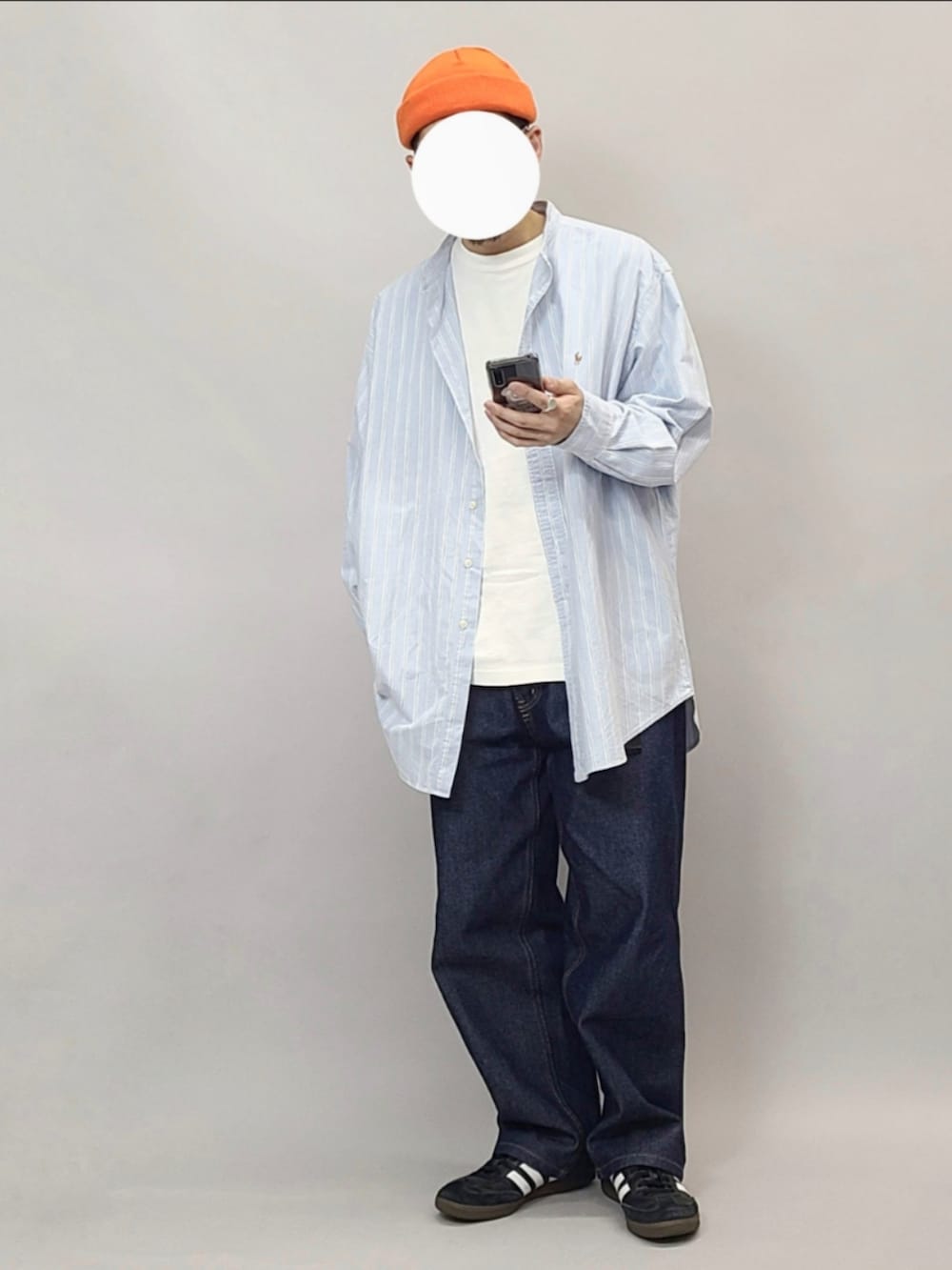 ブラック系のスニーカー、ホワイト系のTシャツ/カットソー、オレンジ系のニットキャップ/ビーニーを着用したメンズの春コーディネートの2枚目の写真