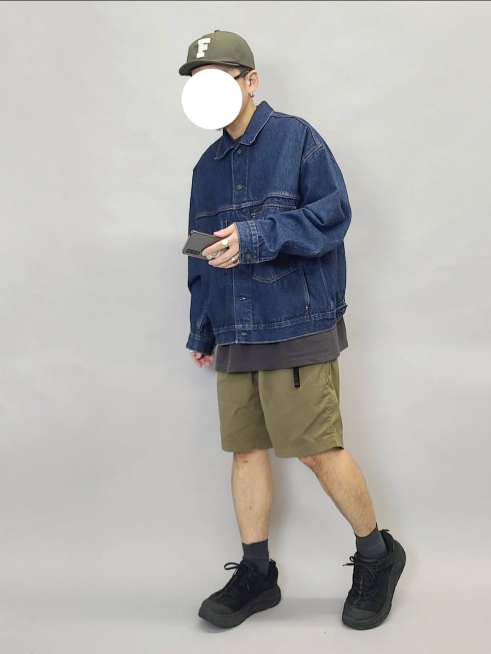 ブルー系のデニムジャケット、ブラック系のTシャツ/カットソー、ブラック系のスニーカーを着用したメンズの秋コーディネートの2枚目の写真