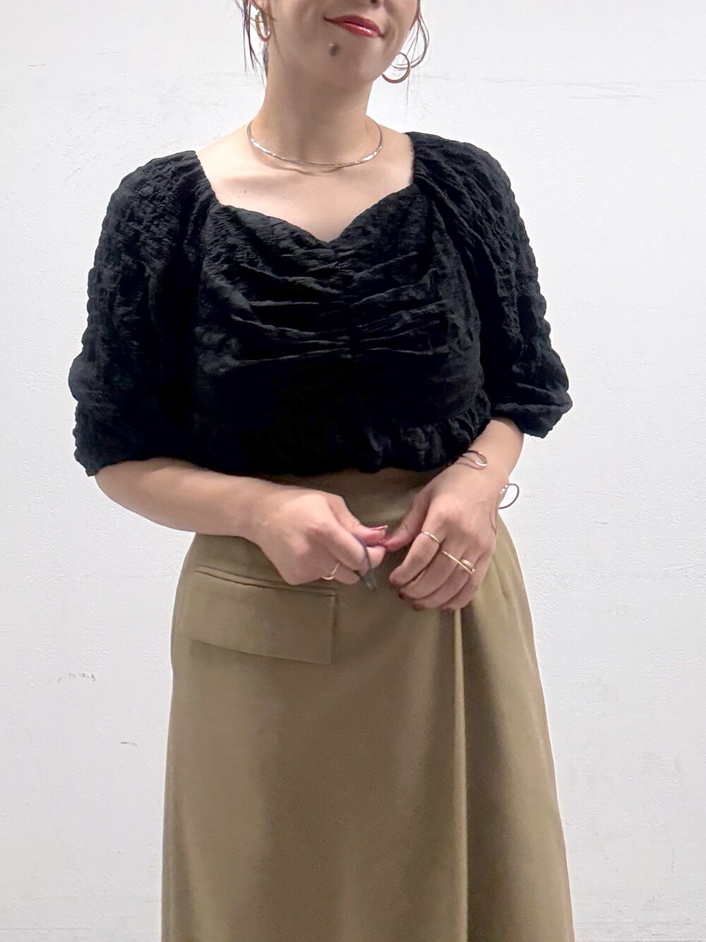 ベージュ系のスカート、ブラック系のシャツ/ブラウス、ブラック系のブーツを着用したレディースの秋コーディネートの4枚目の写真