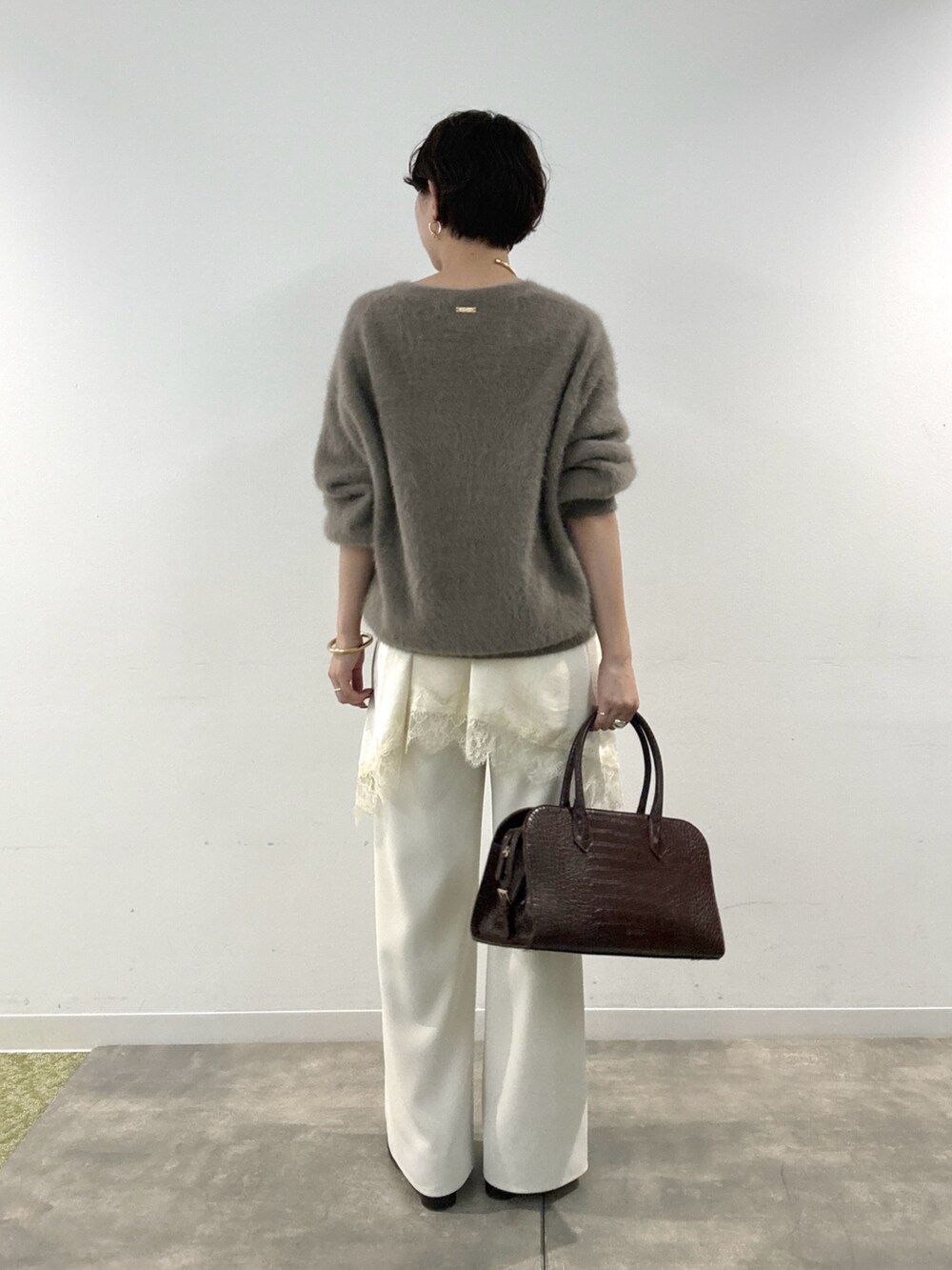 ブラウン系のニット/セーター、ホワイト系のその他パンツ、ホワイト系のキャミソールを着用したレディースの秋コーディネートの3枚目の写真