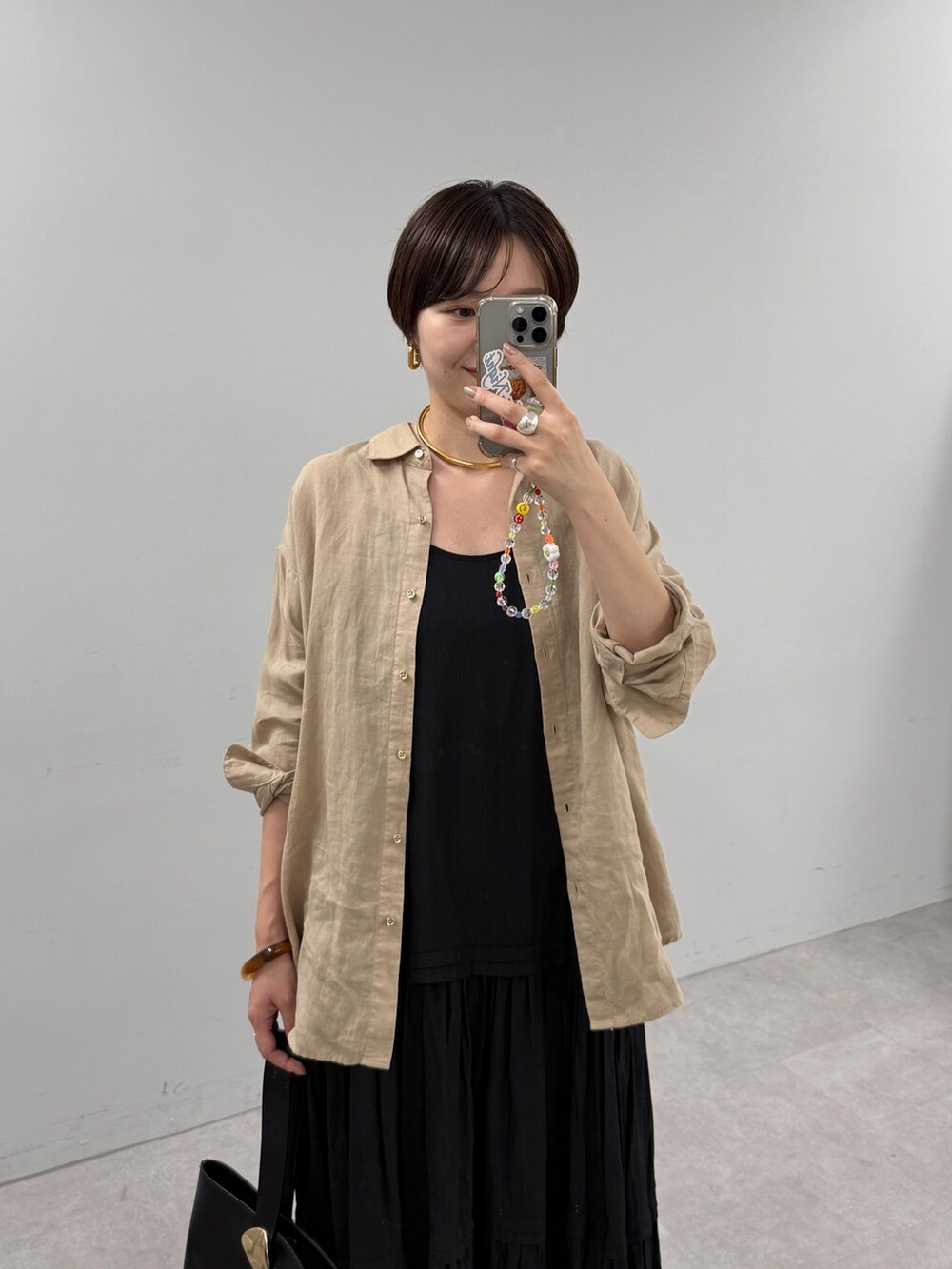 ブラック系のワンピース、ベージュ系のシャツ/ブラウスを着用したレディースの夏コーディネートの2枚目の写真