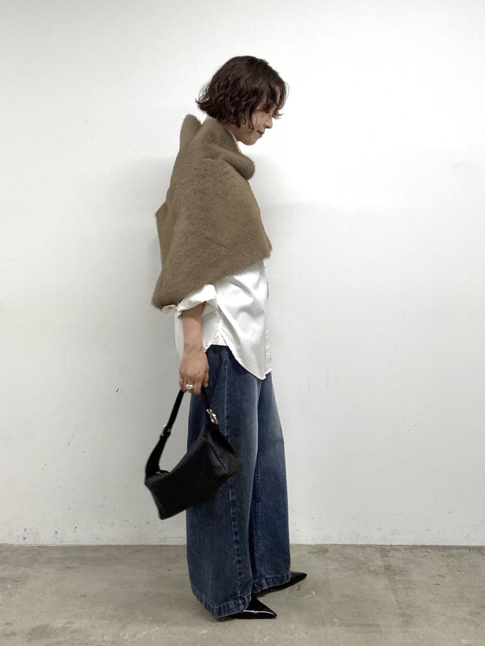 ホワイト系のシャツ/ブラウス、ブルー系のデニムパンツ、ブラック系のパンプスを着用したレディースの秋コーディネートの2枚目の写真