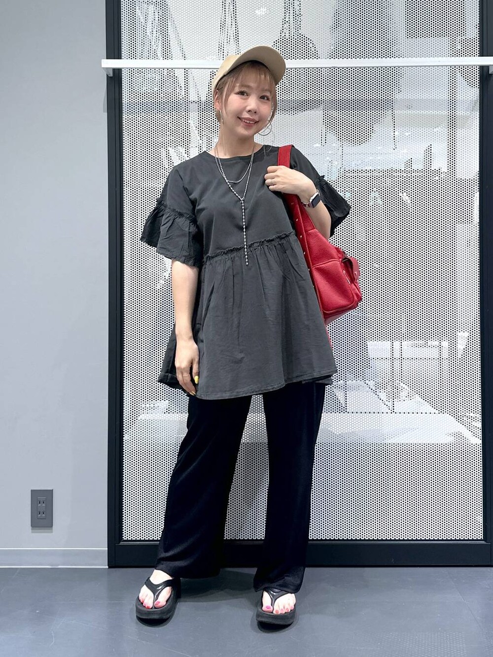 レッド系のショルダーバッグ、ブラック系のサンダル、ブラック系のその他パンツを着用したレディースの夏コーディネートの2枚目の写真