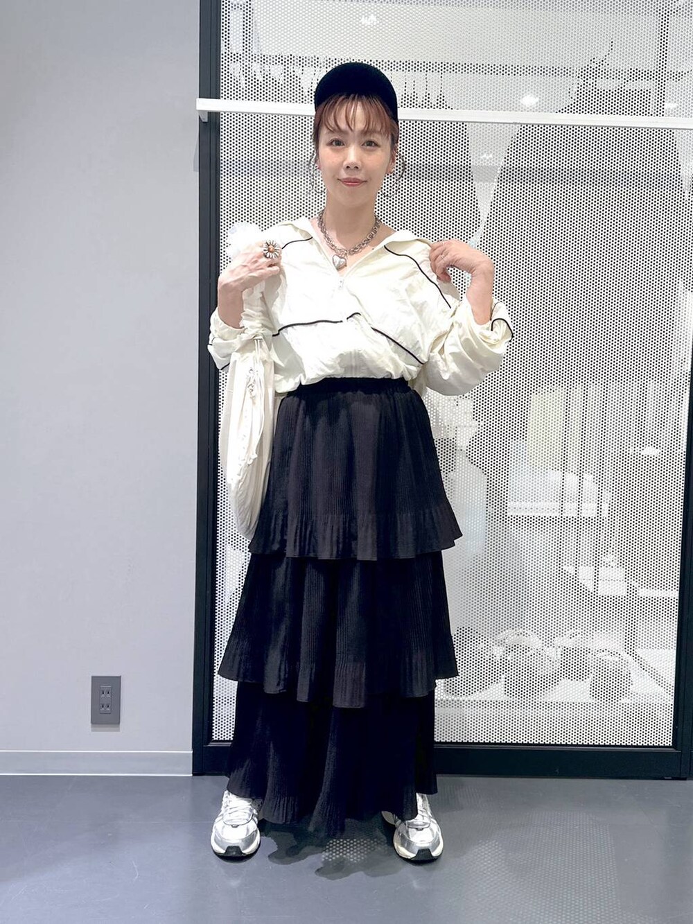 ブラック系のスカート、ホワイト系のショルダーバッグ、ベージュ系のブルゾンを着用したレディースの秋コーディネートの6枚目の写真