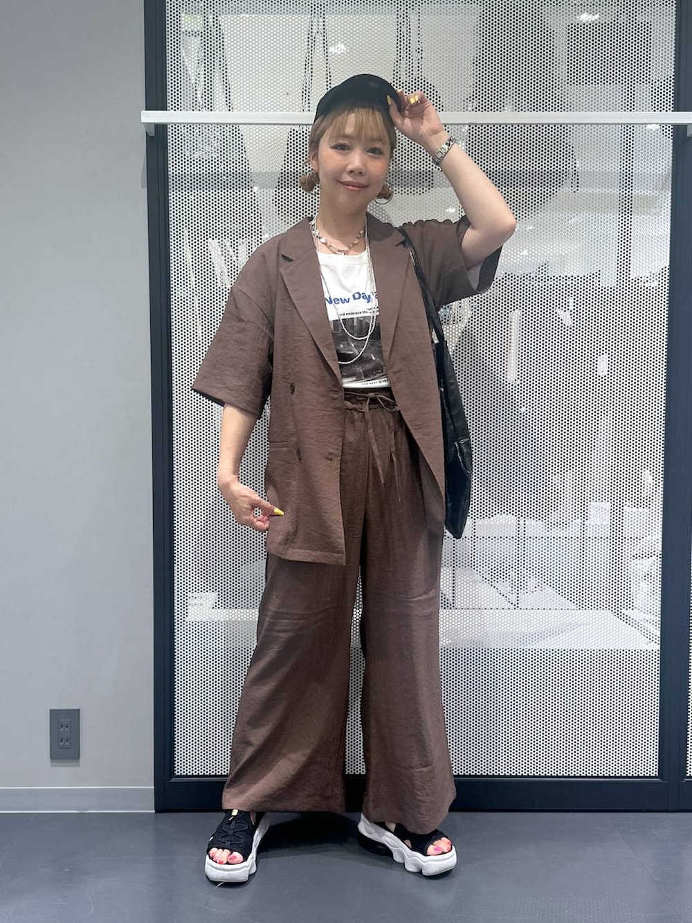 ブラック系のトートバッグ、ブラウン系のテーラードジャケット、ブラウン系のその他パンツを着用したレディースの春コーディネートの2枚目の写真