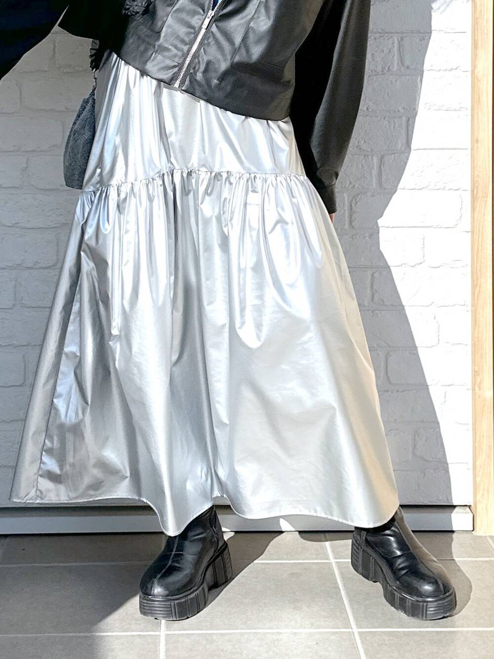 ブラック系のブルゾン、シルバー系のスカート、ブルー系のニット/セーターを着用したレディースの冬コーディネートの5枚目の写真