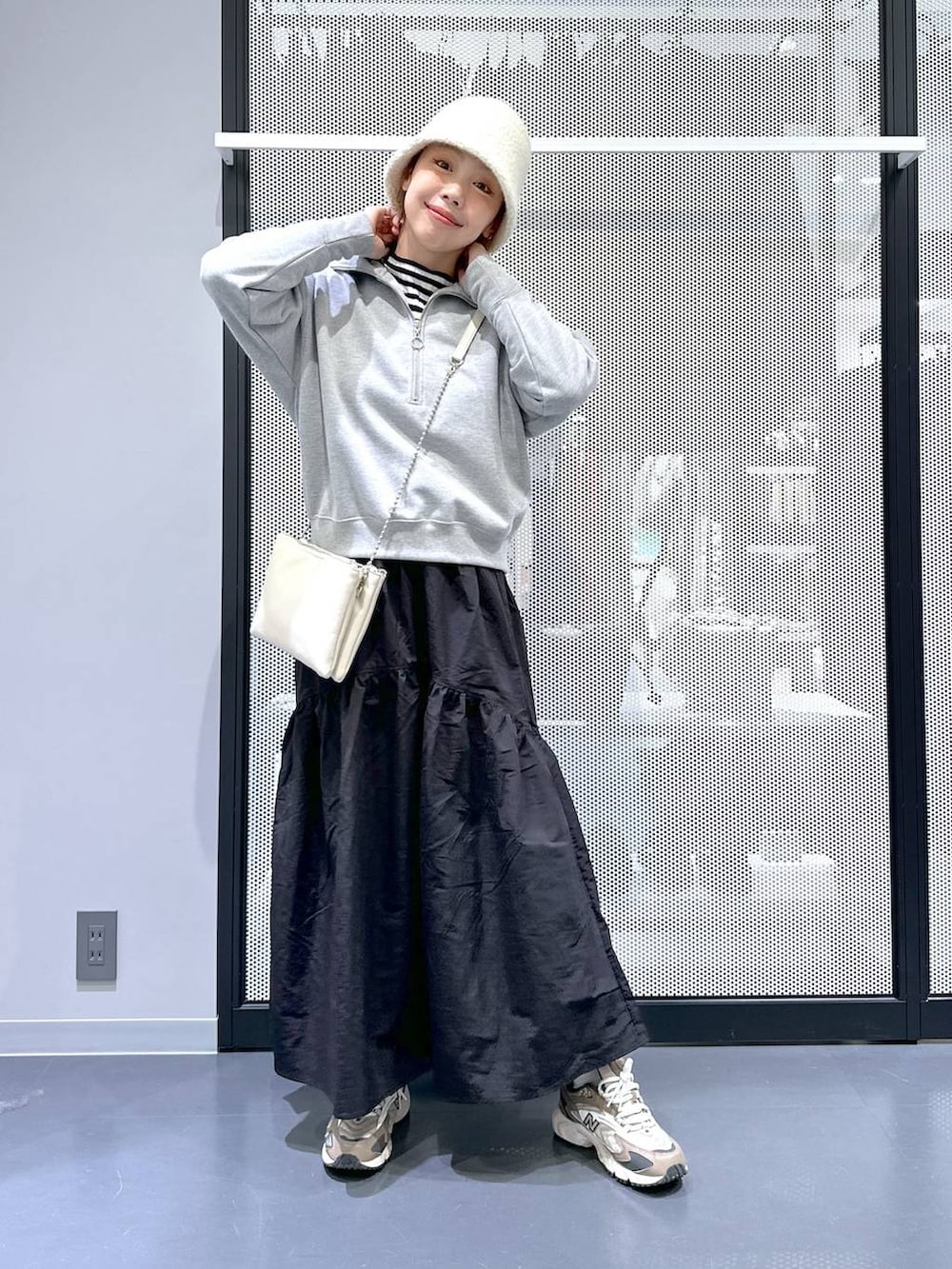 ブラウン系のスニーカー、ホワイト系のショルダーバッグ、その他のニット/セーターを着用したレディースの冬コーディネートの2枚目の写真