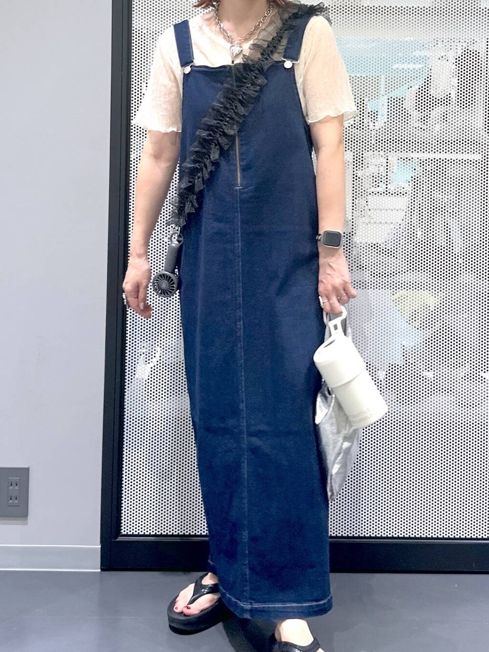 ブルー系のジャンパースカート、ブラック系のサンダル、ベージュ系のTシャツ/カットソーを着用したレディースの夏コーディネートの7枚目の写真