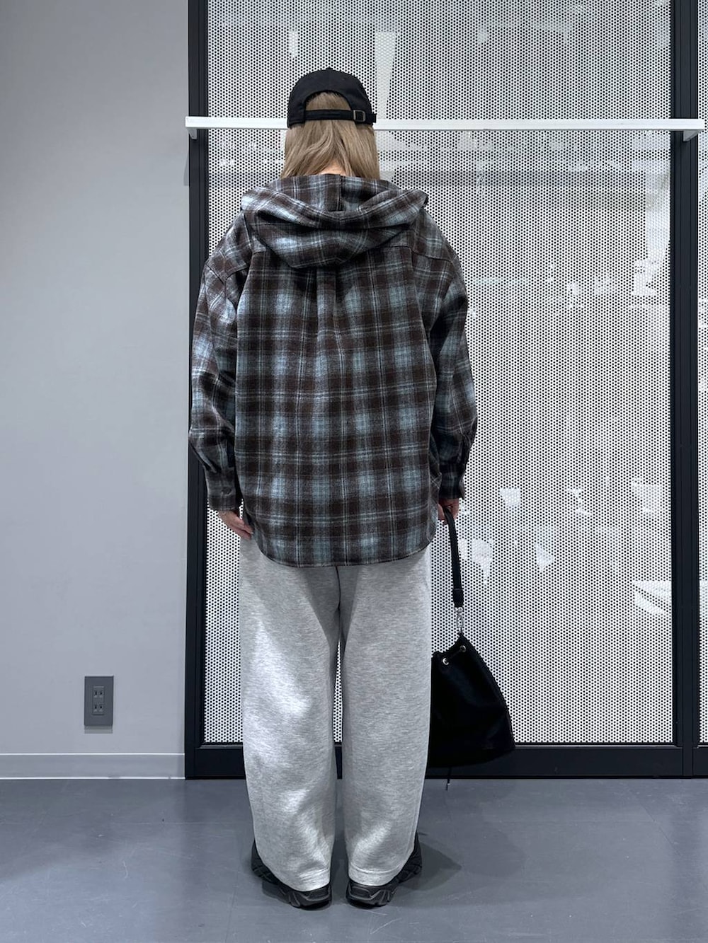 ブラック系のショルダーバッグ、ホワイト系のTシャツ/カットソー、グレー系のスウェットパンツを着用したレディースの秋コーディネートの3枚目の写真