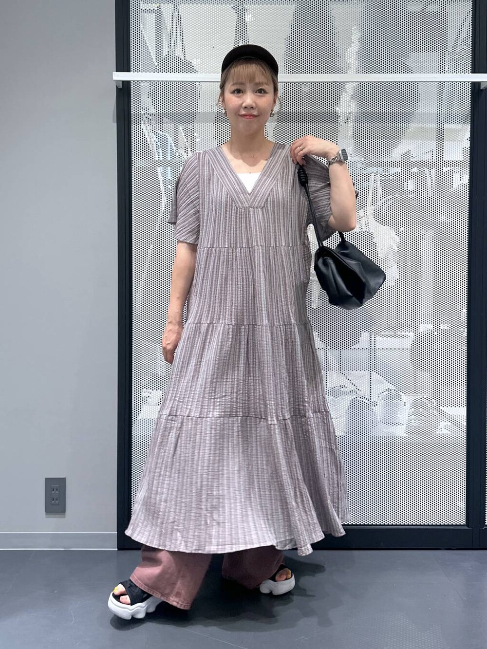 ホワイト系のキャミソール、グレー系のワンピース、ブラック系のショルダーバッグを着用したレディースの夏コーディネートの5枚目の写真